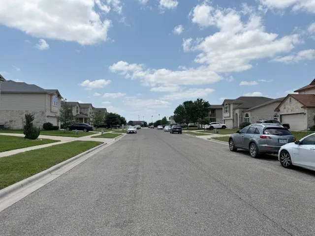 View of asphalt street with a residential view, sidewalks, and curbs