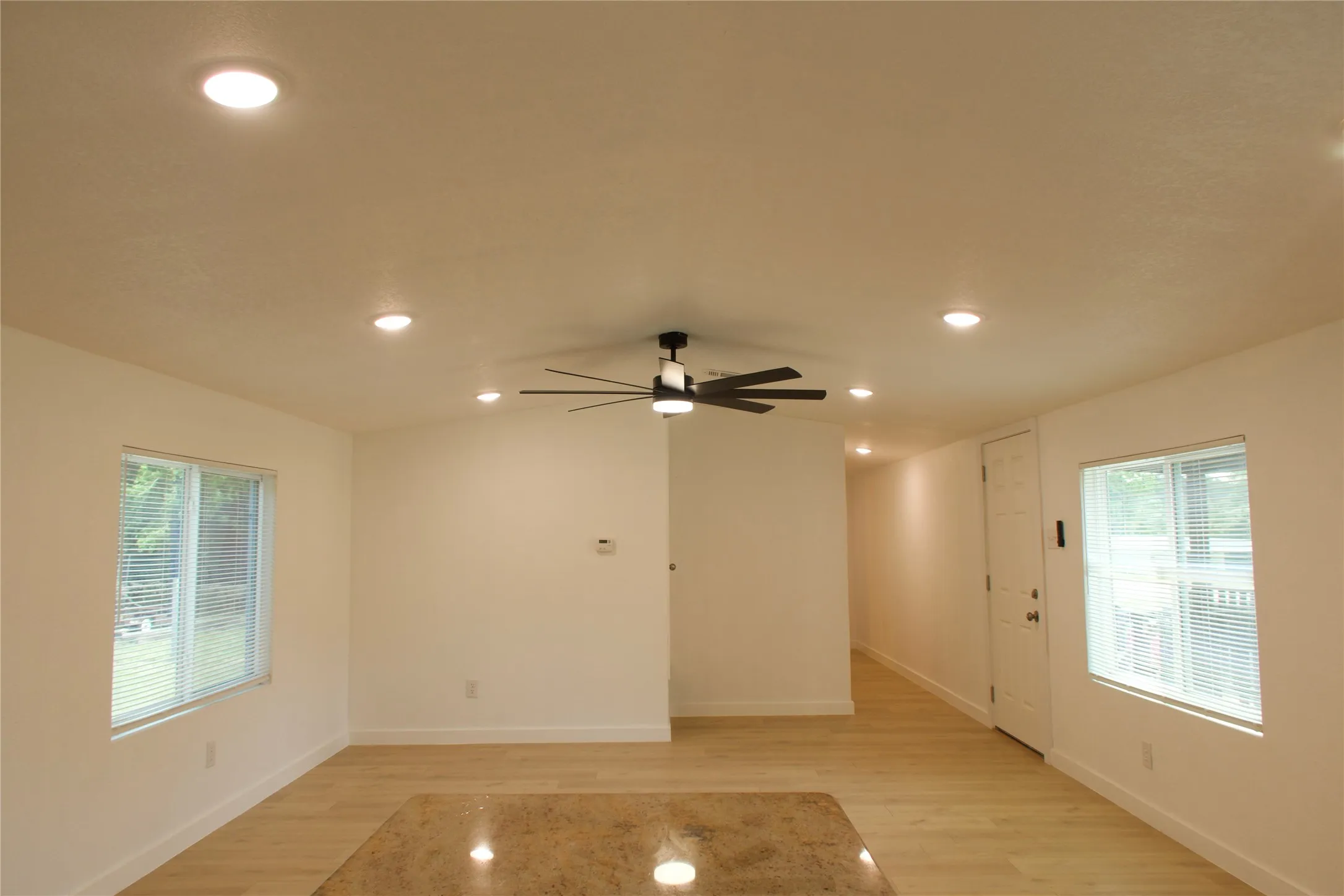 Unfurnished room with light wood finished floors, healthy amount of natural light, recessed lighting, ceiling fan, and baseboards