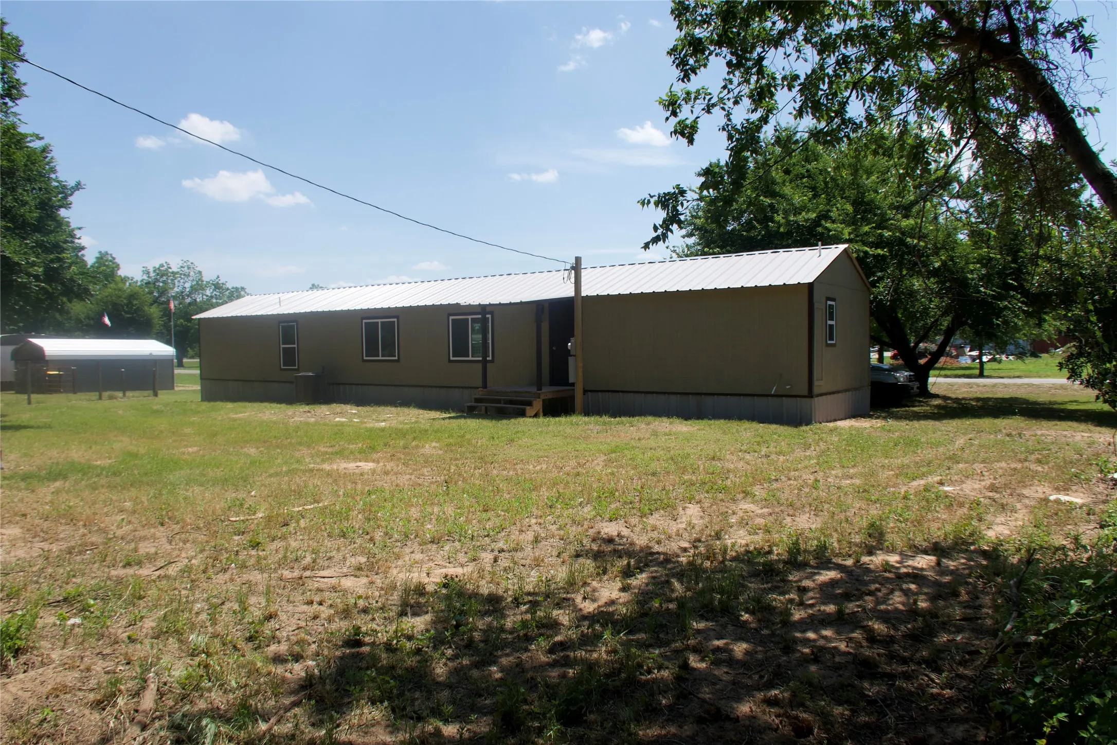 Rear view of property with a yard and metal roof
