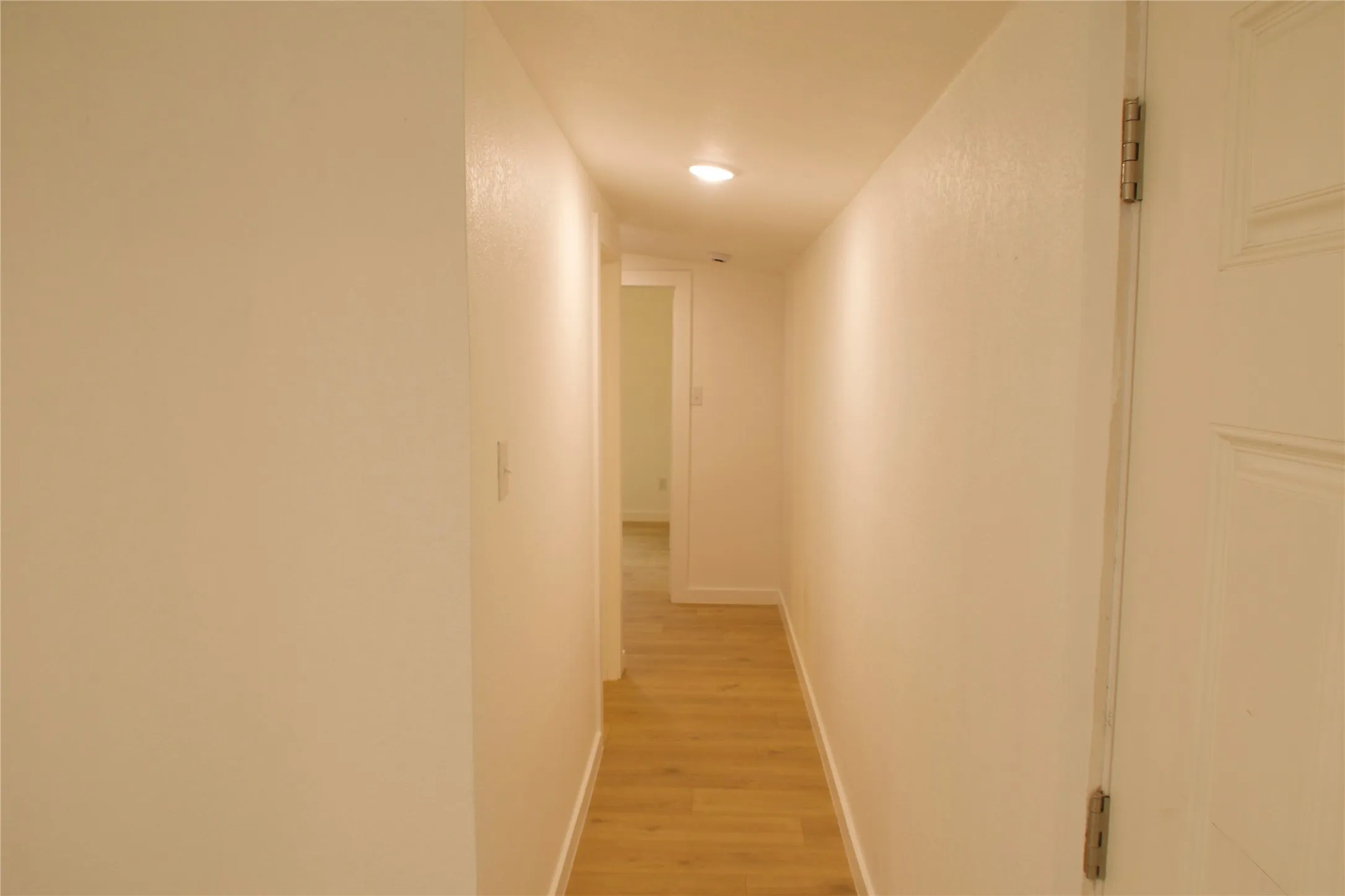 Corridor featuring light wood-style floors, baseboards, and recessed lighting