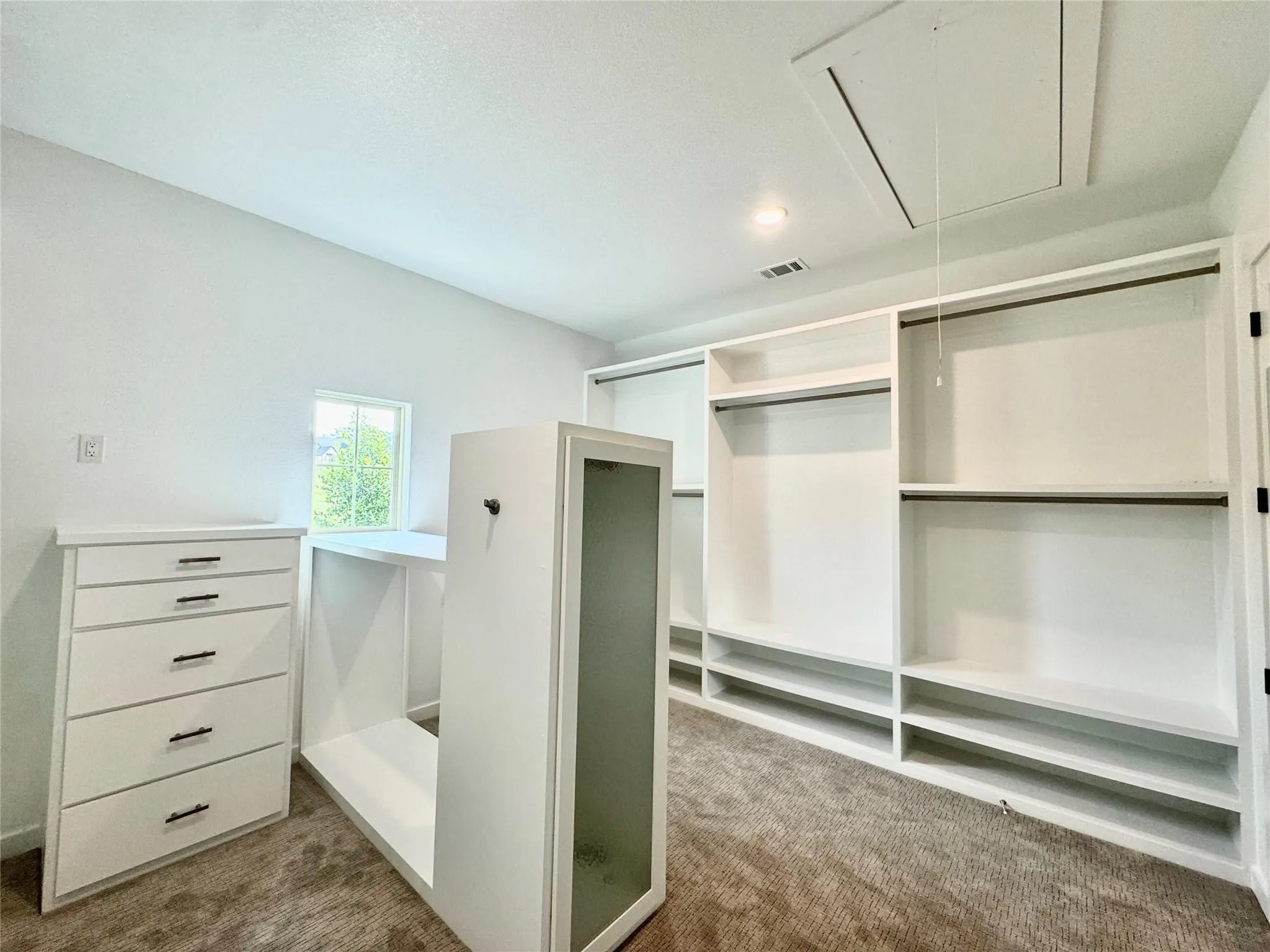 Spacious closet featuring attic access and carpet