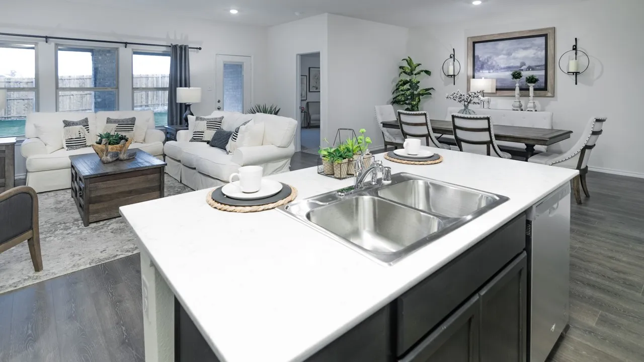 Kitchen featuring a kitchen island with sink, light countertops, open floor plan, dishwasher, and recessed lighting