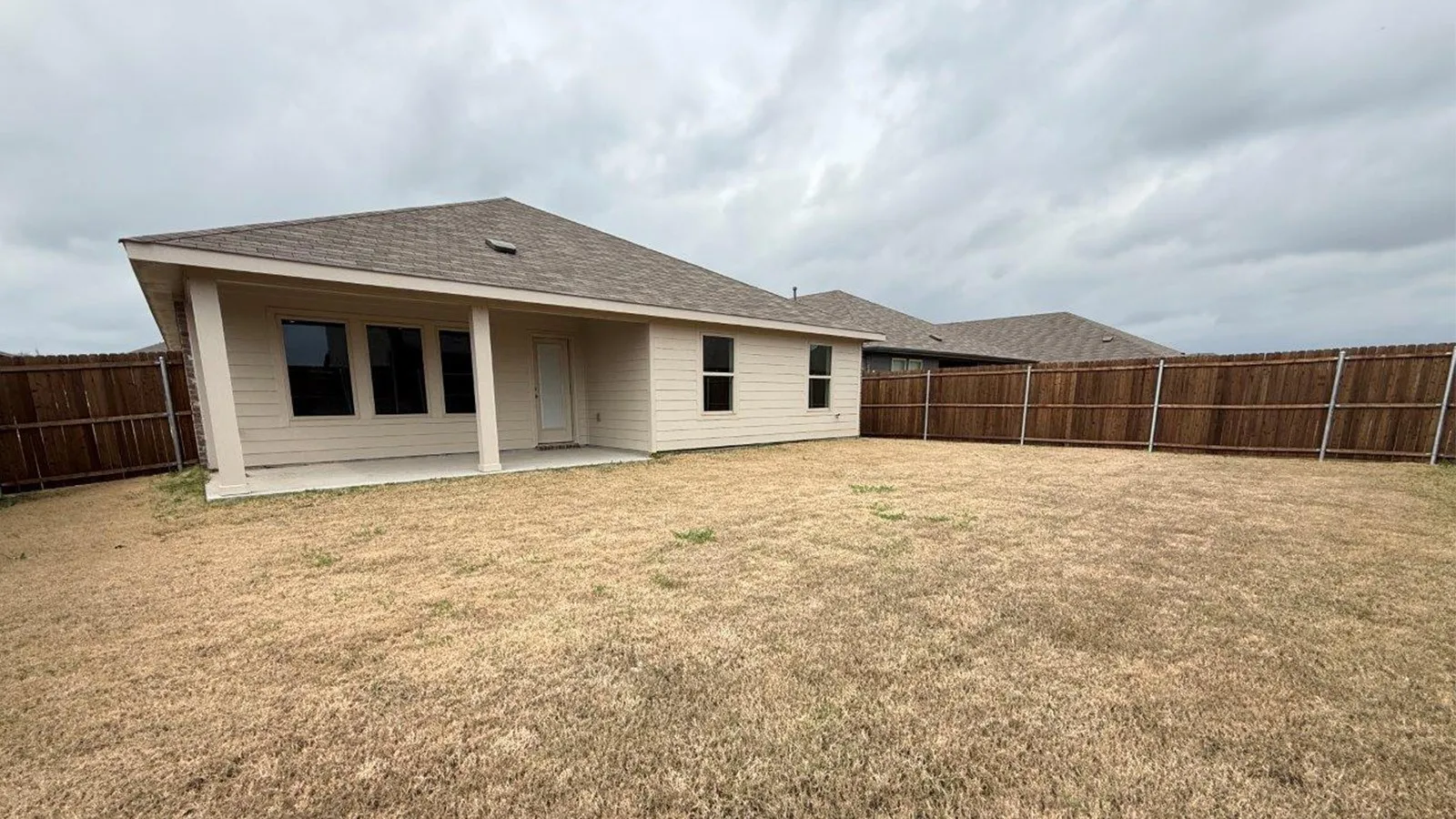 Rear view of house with a patio area, a fenced backyard, and a shingled roof