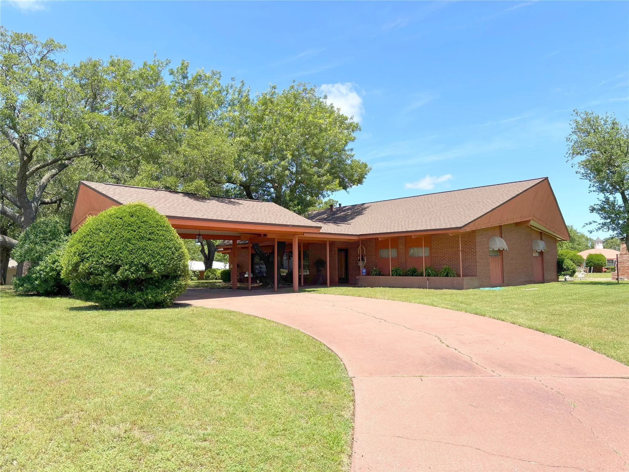View of front of home with a front yard, driveway, and roof with shingles