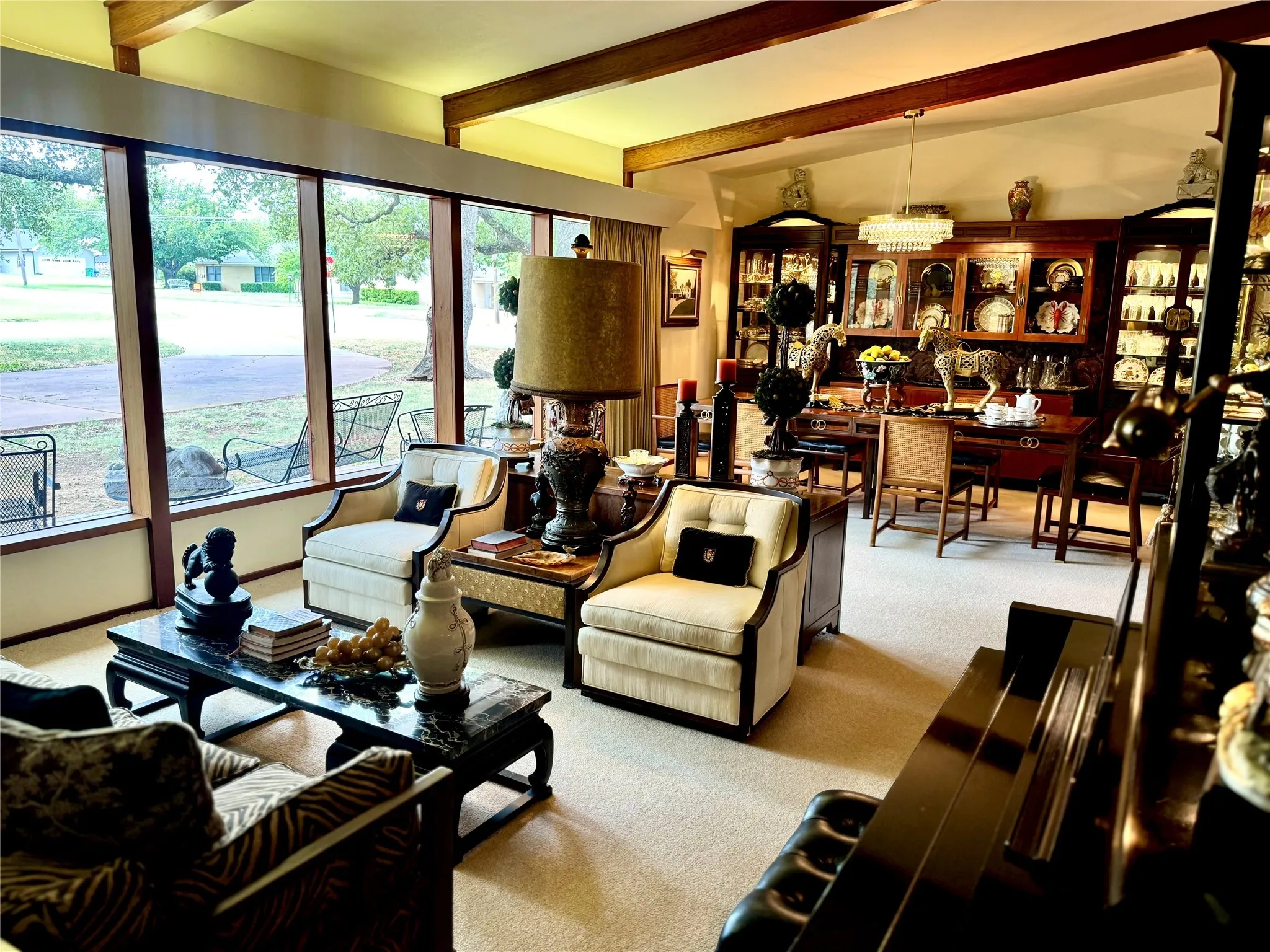 Living area with beamed ceiling and light colored carpet