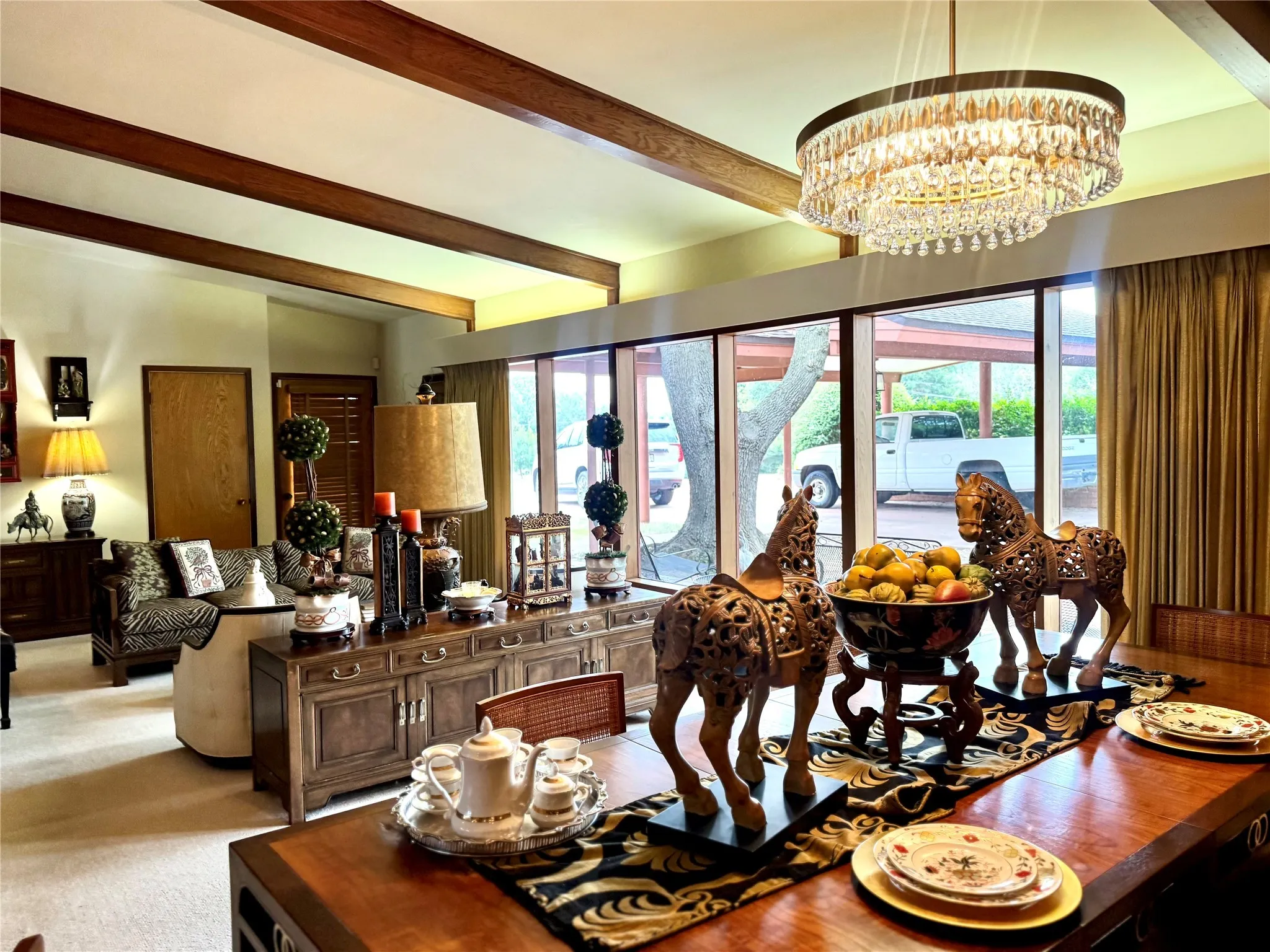 Dining space with beam ceiling, carpet floors, and a chandelier