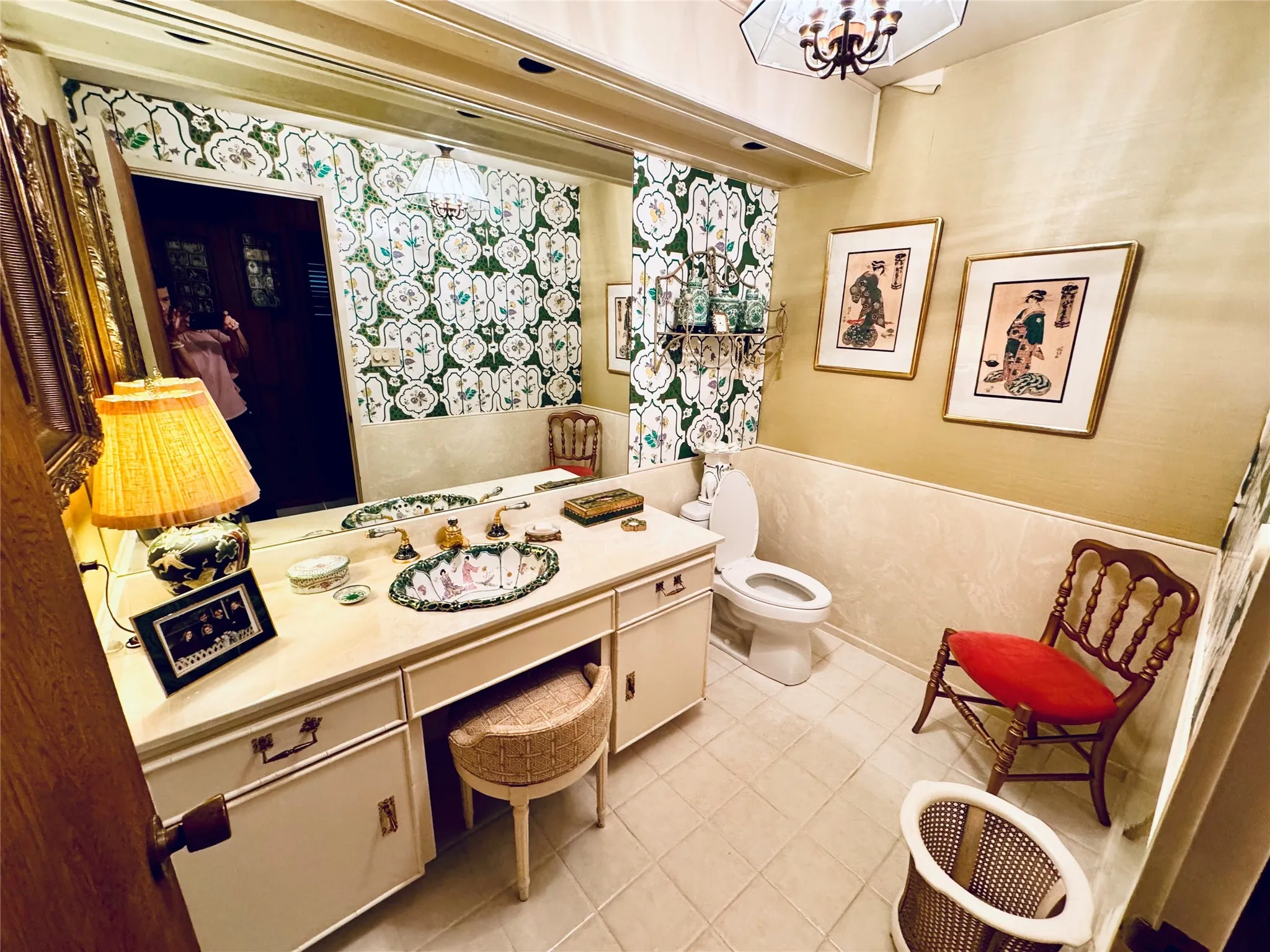Bathroom featuring wallpapered walls, vanity, and a chandelier