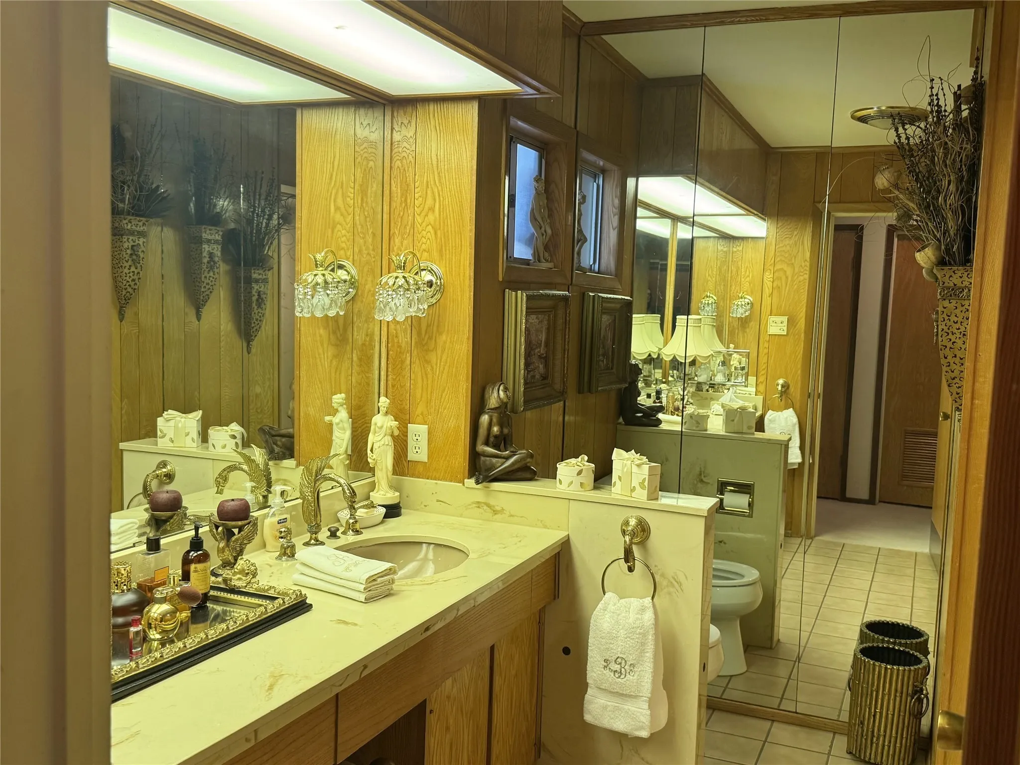 Bathroom with light tile patterned floors, vanity, and wooden walls