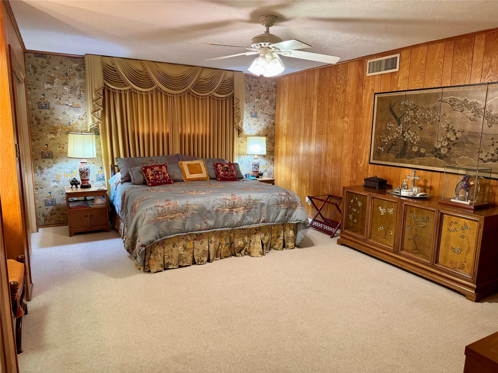 Bedroom with carpet floors, a ceiling fan, and wood walls