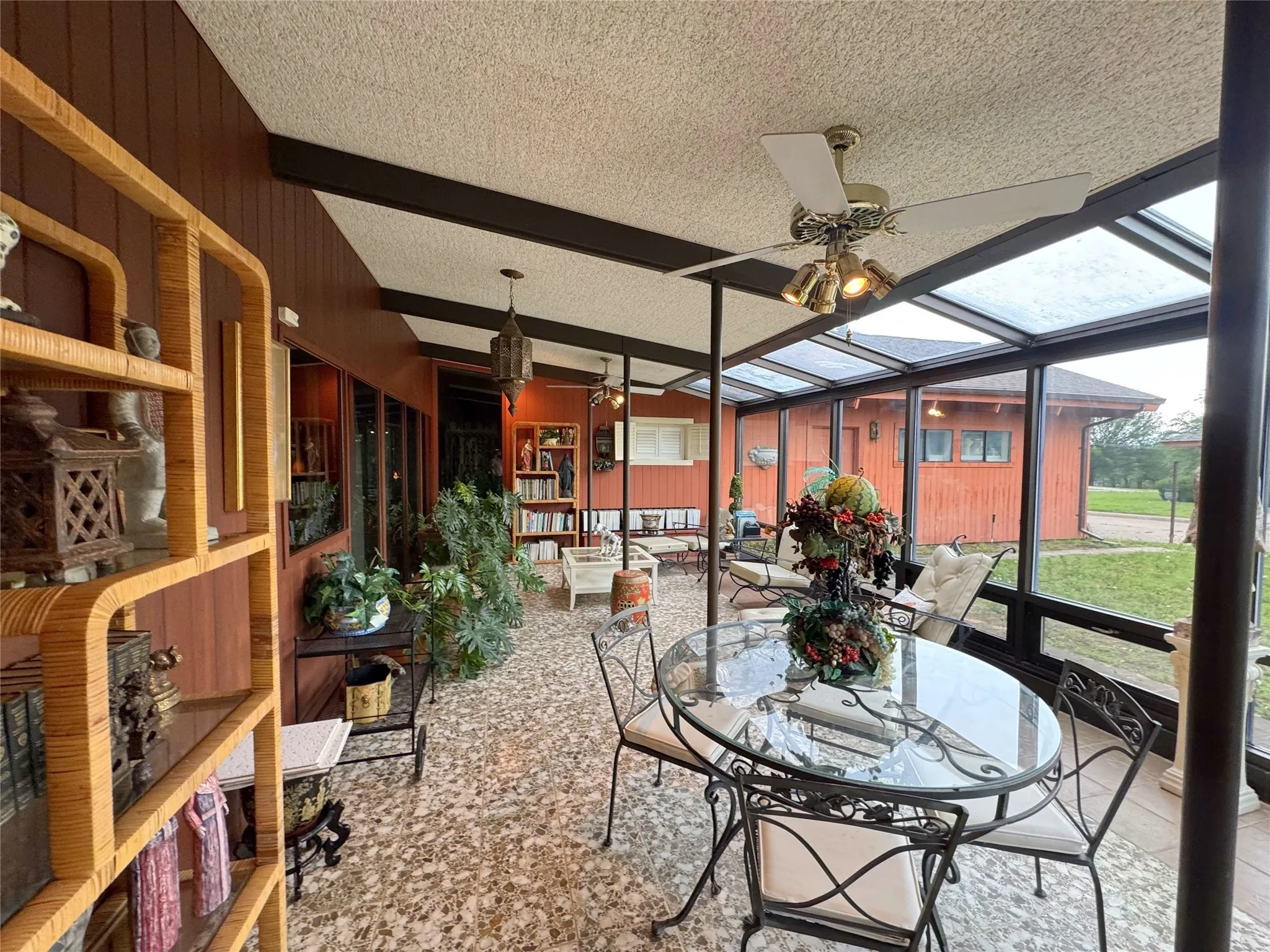 Sunroom featuring a ceiling fan, outdoor dining space, and beam ceiling