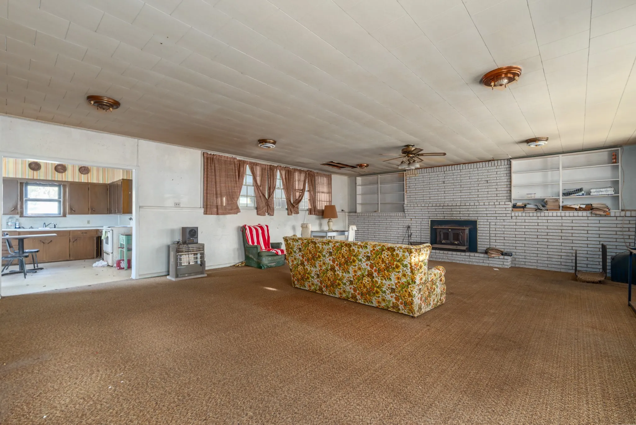 Living area featuring carpet floors, brick wall, and a brick fireplace