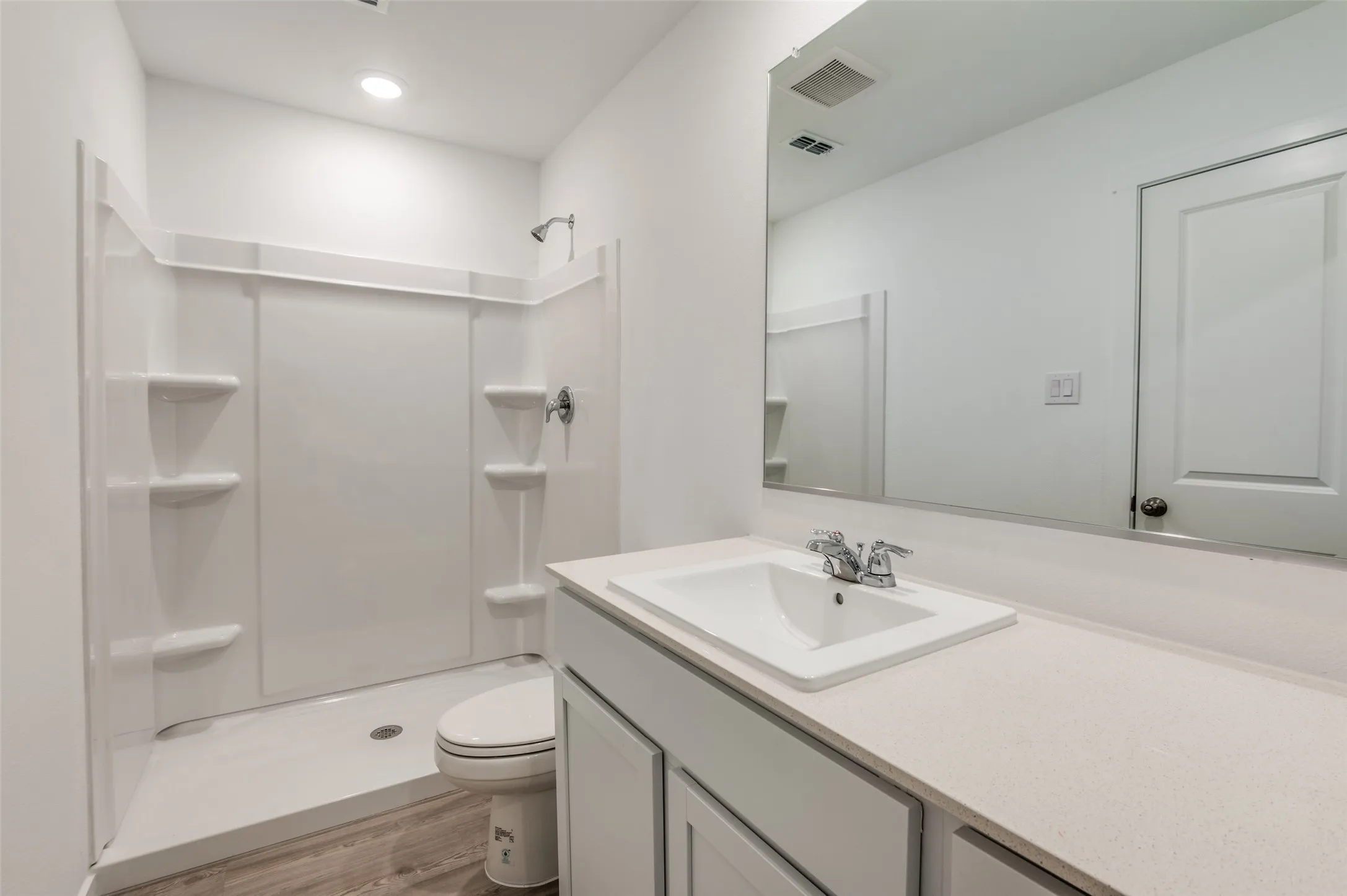 Bathroom featuring walk in shower, wood-type flooring, toilet, and vanity
