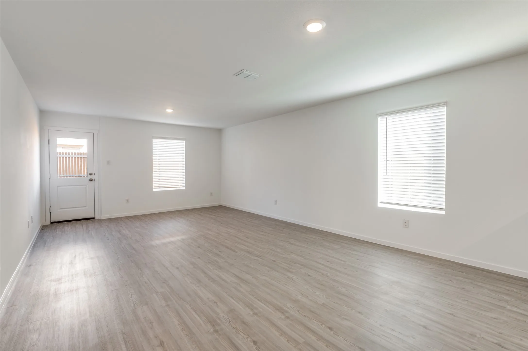 Empty room with light hardwood / wood-style floors