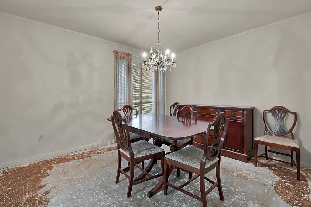 Dining room featuring a chandelier, baseboards, and crown molding