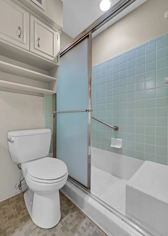 Full bath with toilet and a stall shower