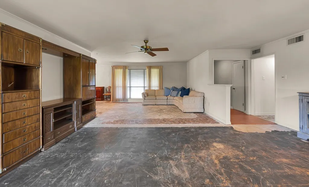Living area featuring a ceiling fan and ornamental molding
