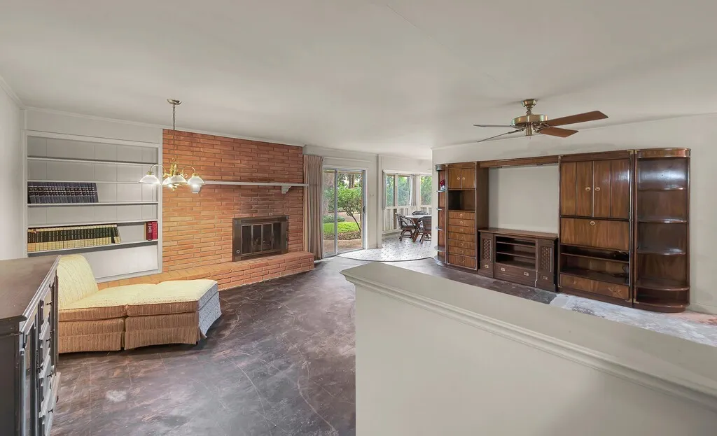 Unfurnished living room featuring a fireplace and a ceiling fan