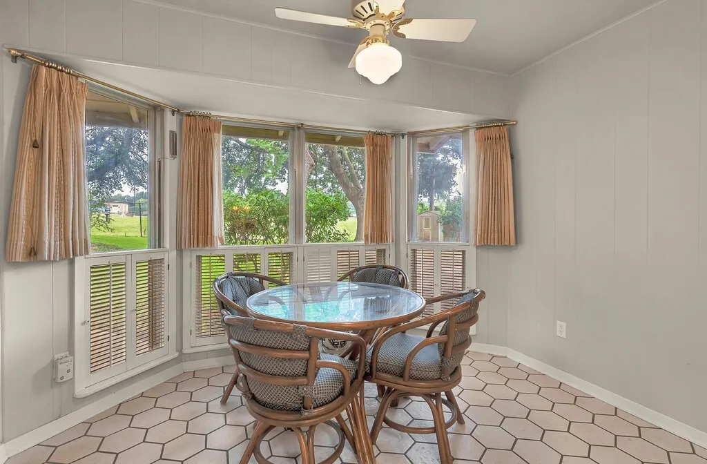 Dining room with a ceiling fan, ornamental molding, light tile patterned floors, and baseboards