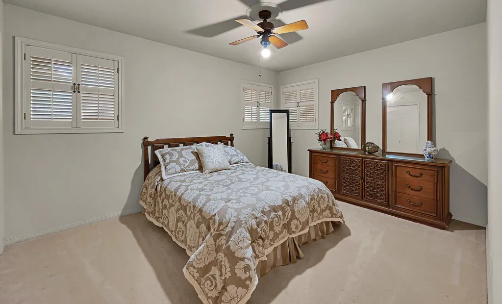 Bedroom featuring carpet floors, baseboards, and ceiling fan