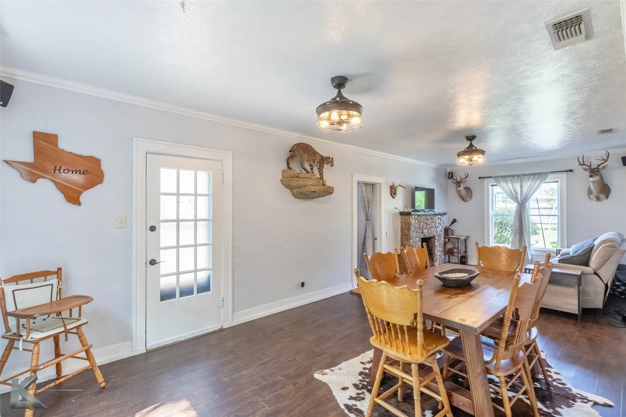 Dining room featuring wood finished floors, crown molding, baseboards, and a fireplace