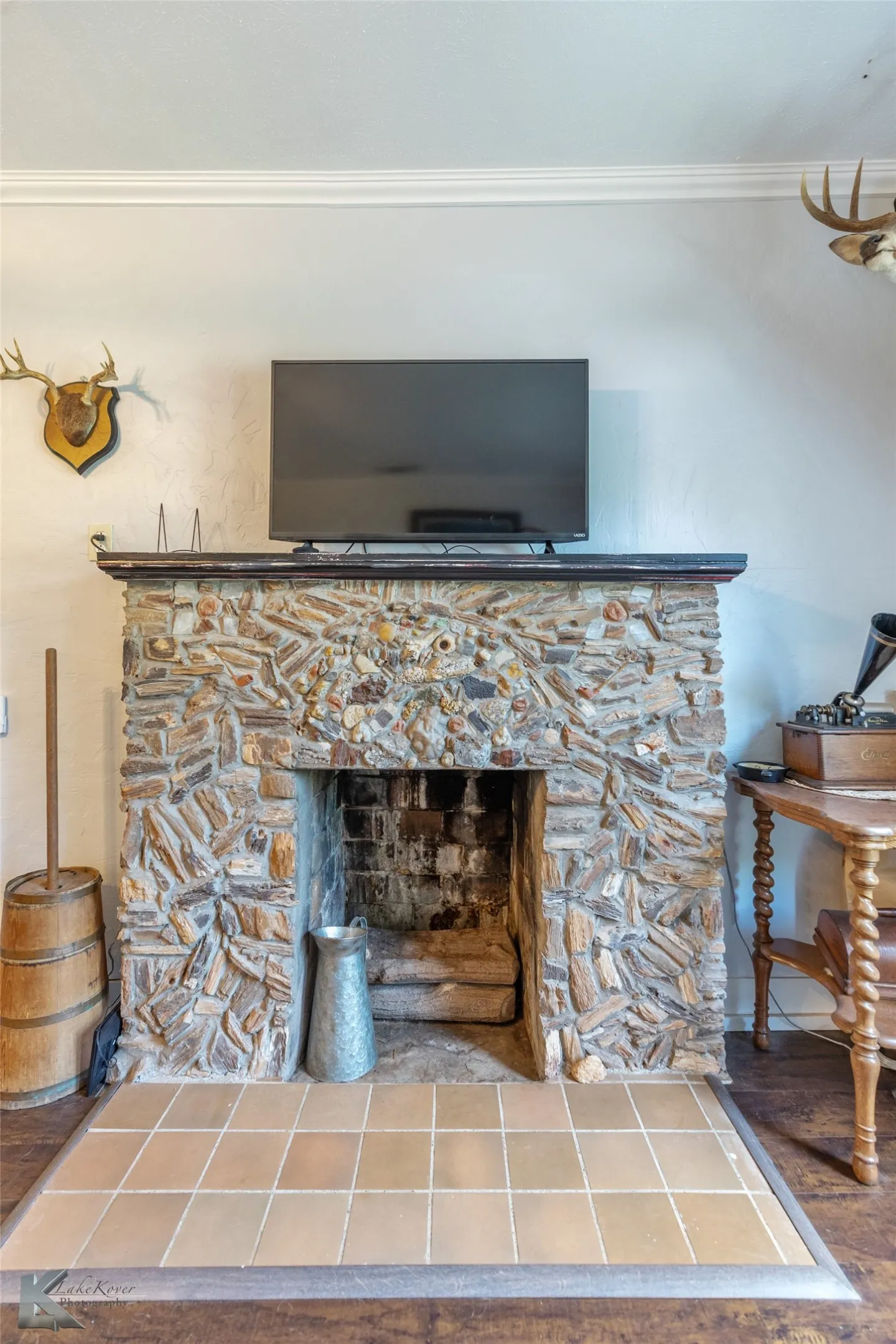 Detailed view of ornamental molding, a fireplace, and wood finished floors