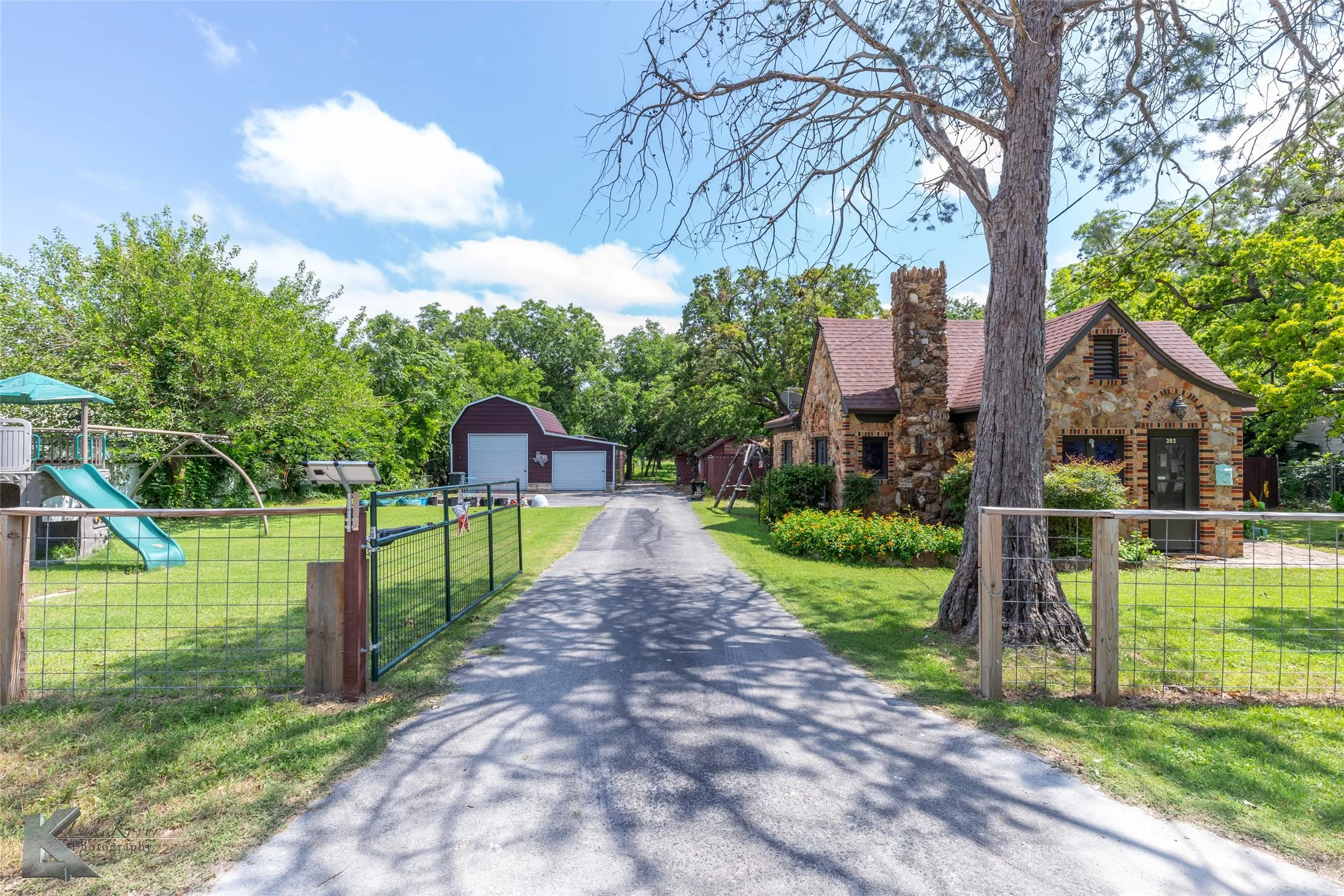 View of front facade with a detached garage, an outdoor structure, a chimney, and a gate