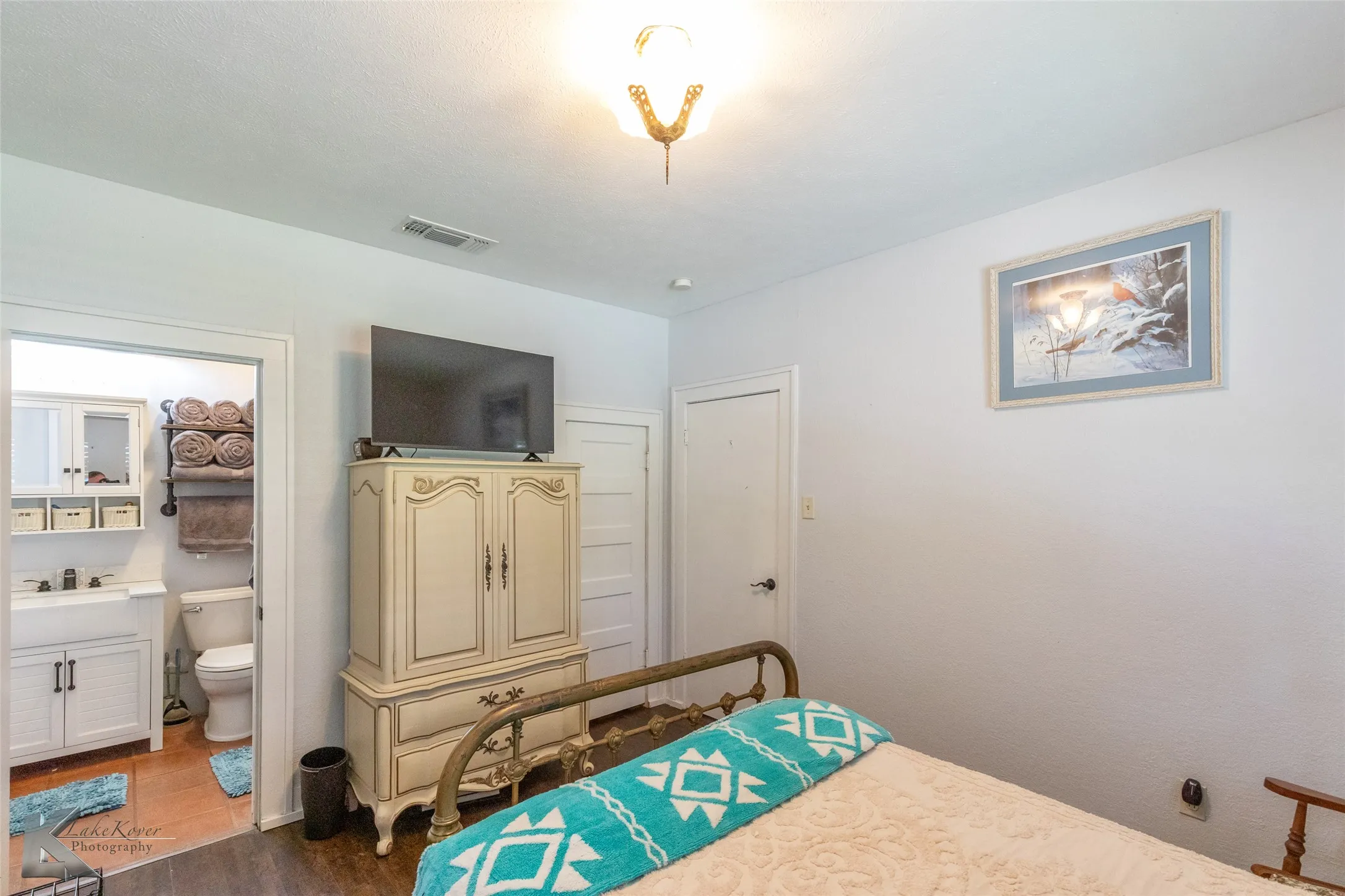 Bedroom featuring wood finished floors and connected bathroom