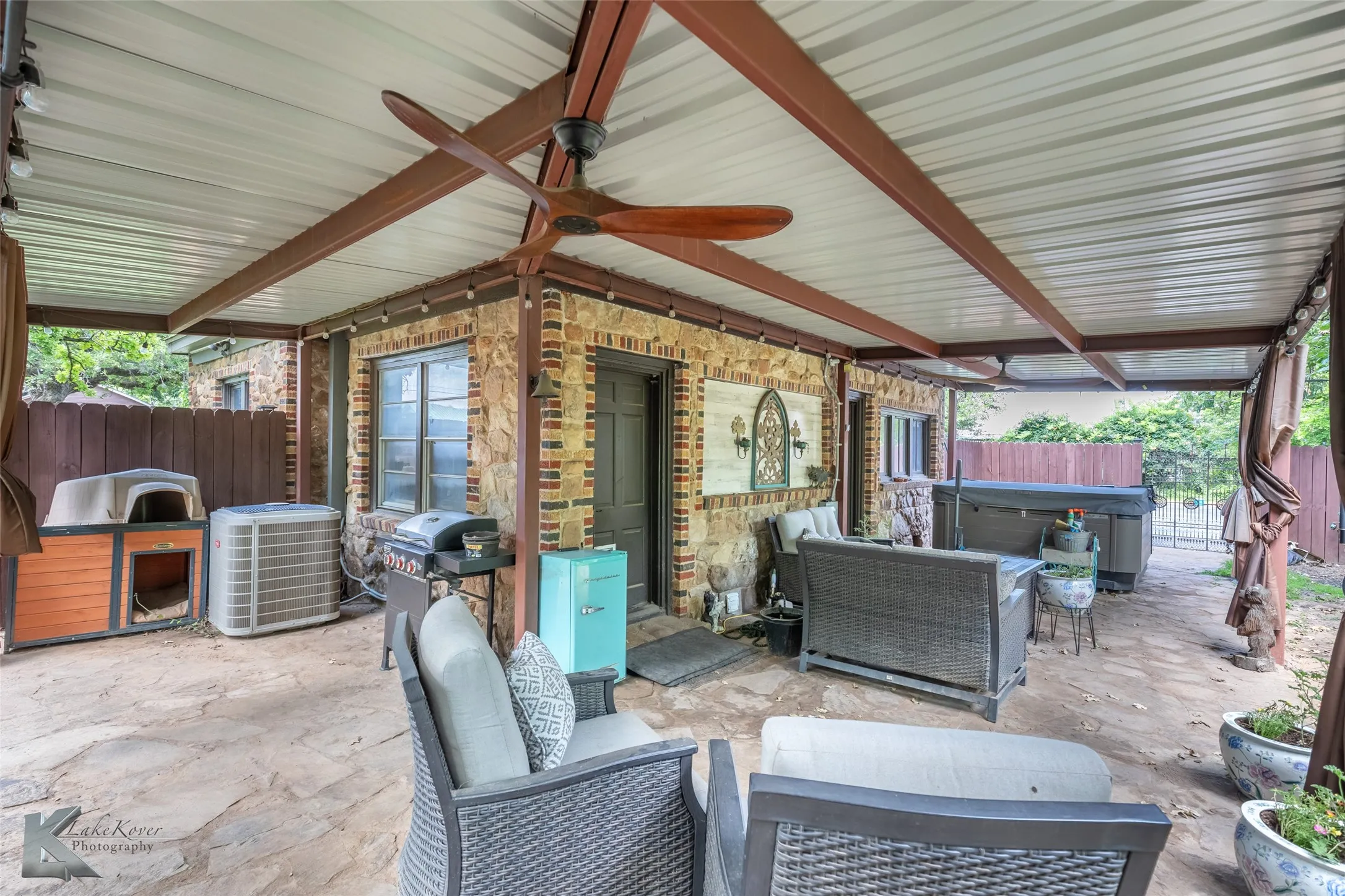 View of patio featuring a hot tub, ceiling fan, grilling area, cooling unit, and an outdoor living space