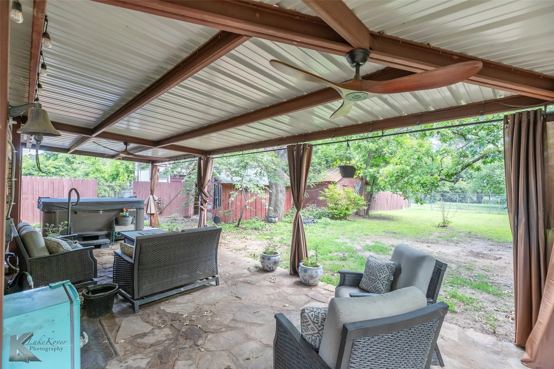 View of patio / terrace with ceiling fan, a hot tub, and an outdoor living space
