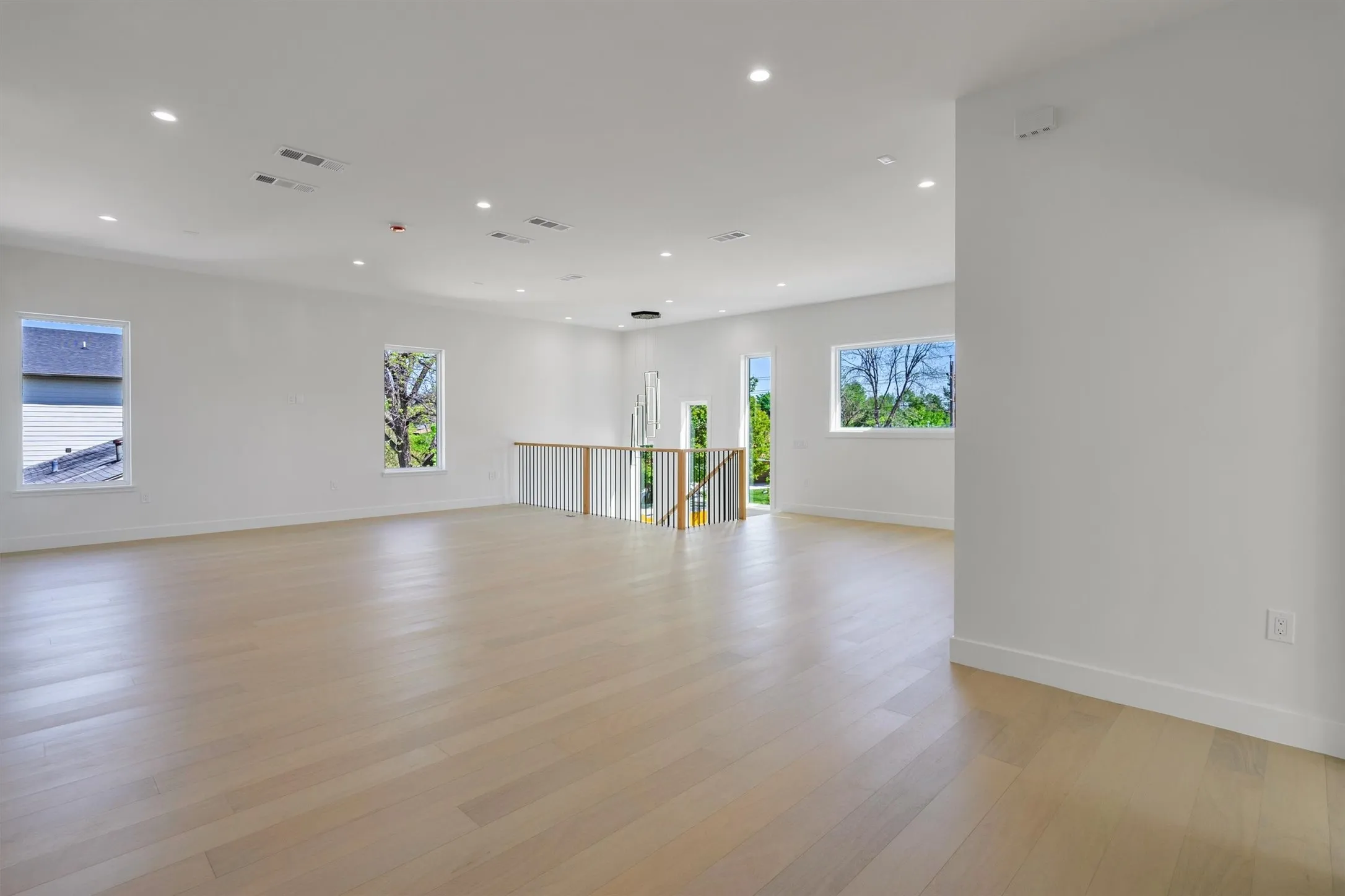 Unfurnished room with healthy amount of natural light, recessed lighting, light wood finished floors, and baseboards