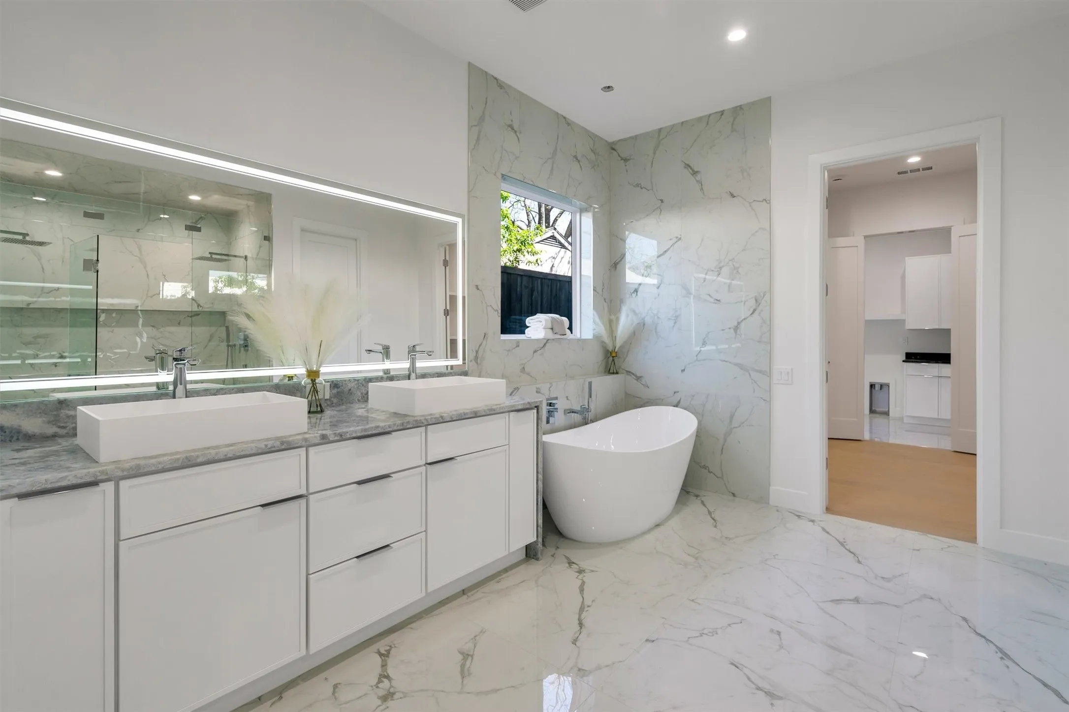 Full bathroom featuring double vanity, a marble finish shower, a freestanding bath, marble tiled floors, and recessed lighting