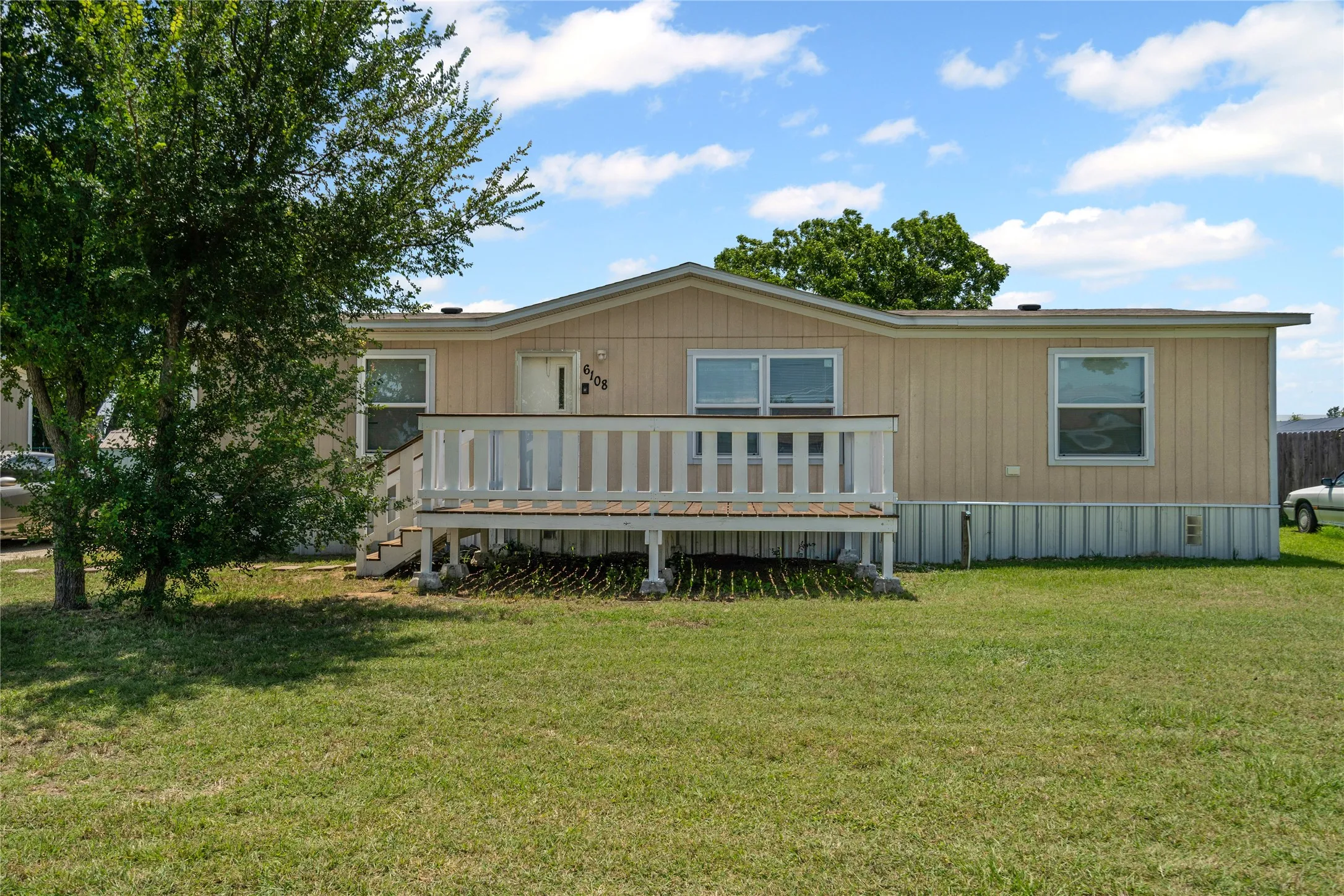 Rear view of property with a wooden deck and a yard