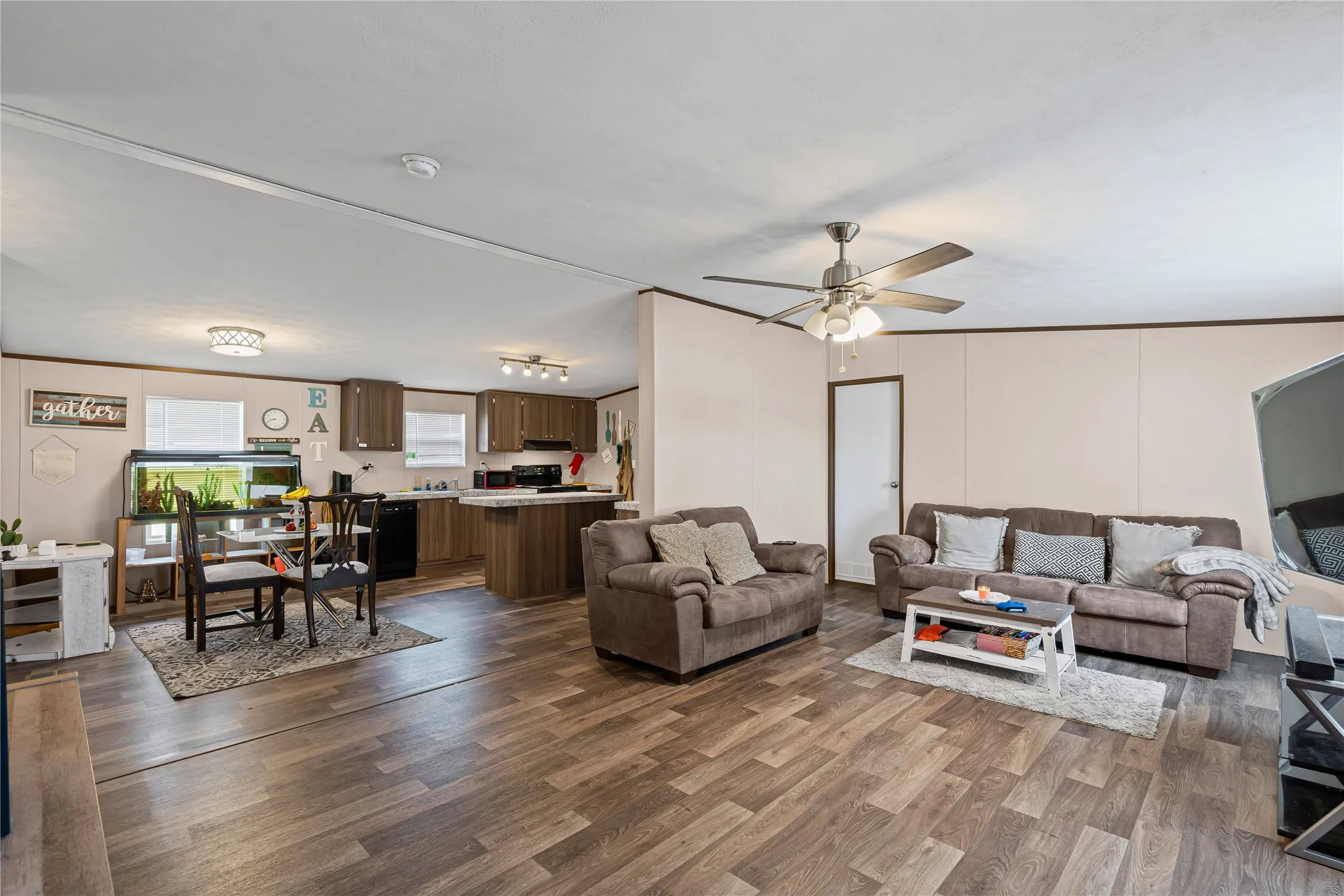 Living room with dark wood-style flooring and a ceiling fan