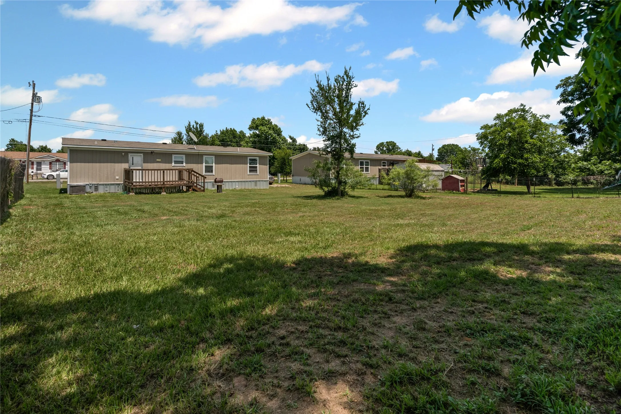 View of yard with a wooden deck and a storage shed