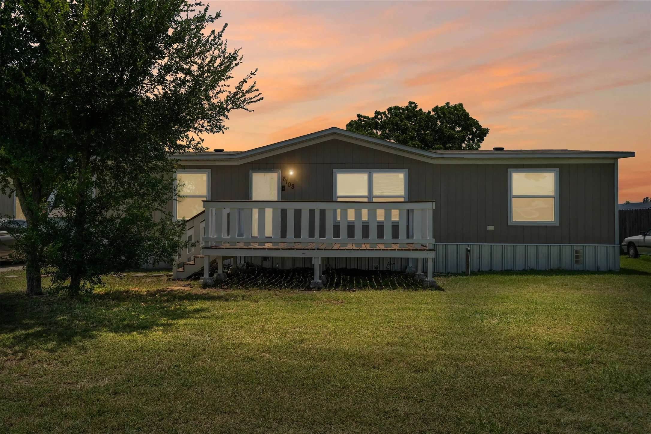 Rear view of property with a wooden deck and a lawn