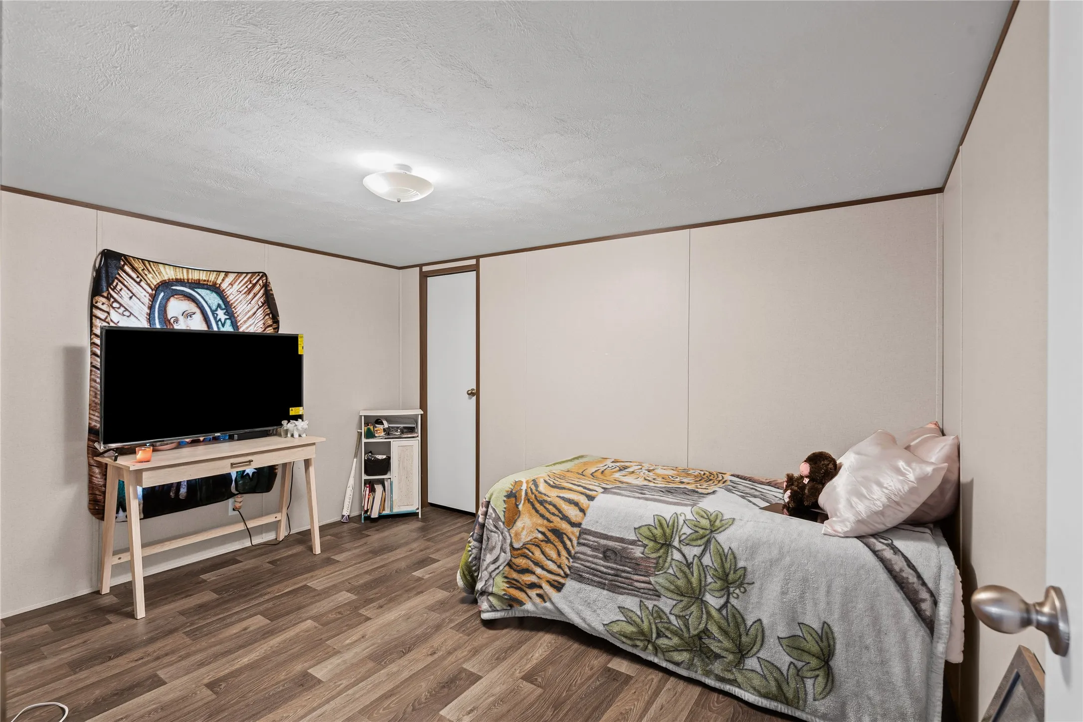 Bedroom featuring wood finished floors and a textured ceiling