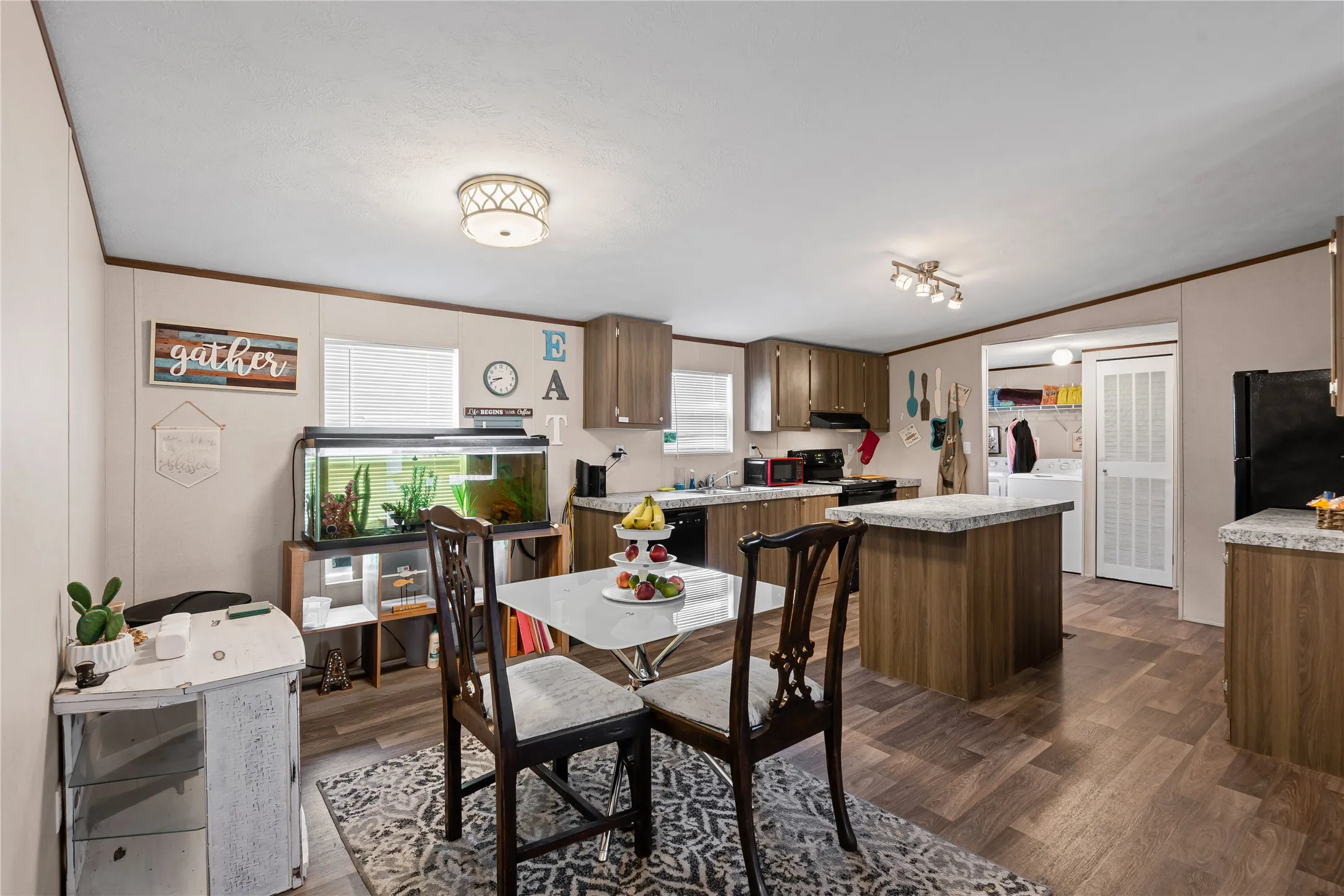 Dining room featuring independent washer and dryer, dark wood-style floors, and ornamental molding