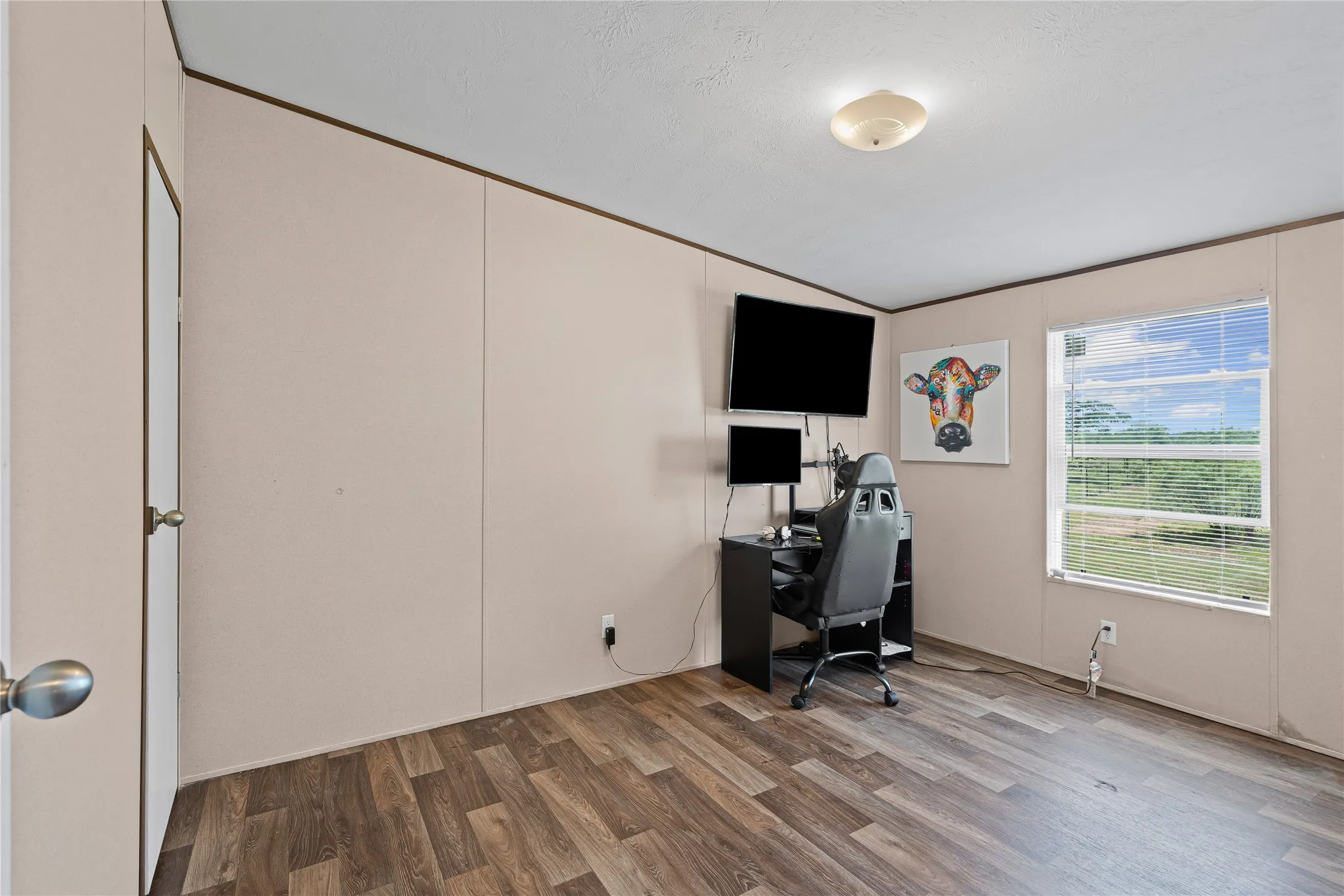 Home office featuring wood finished floors and vaulted ceiling