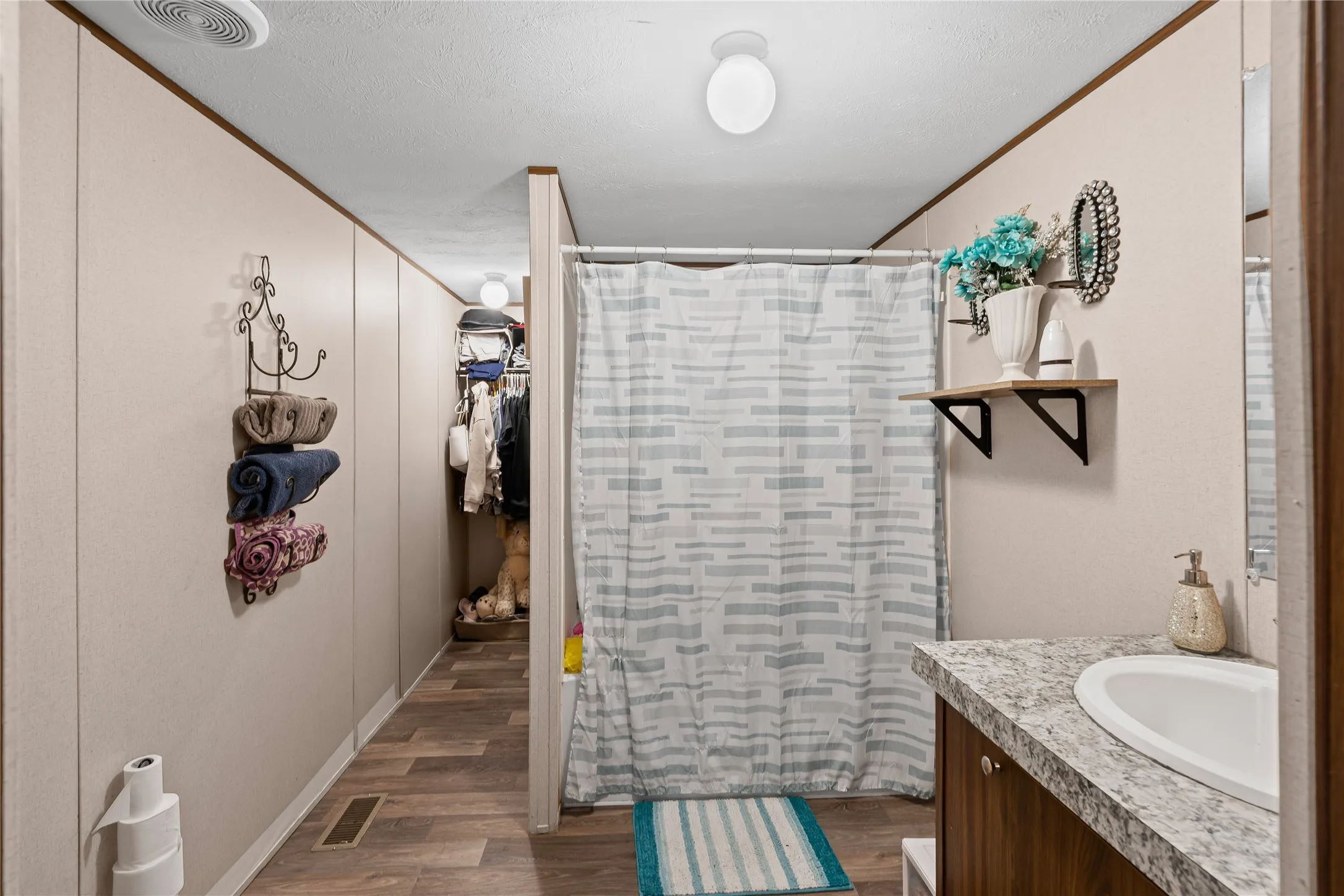 Full bath featuring vanity, a shower with shower curtain, and wood finished floors
