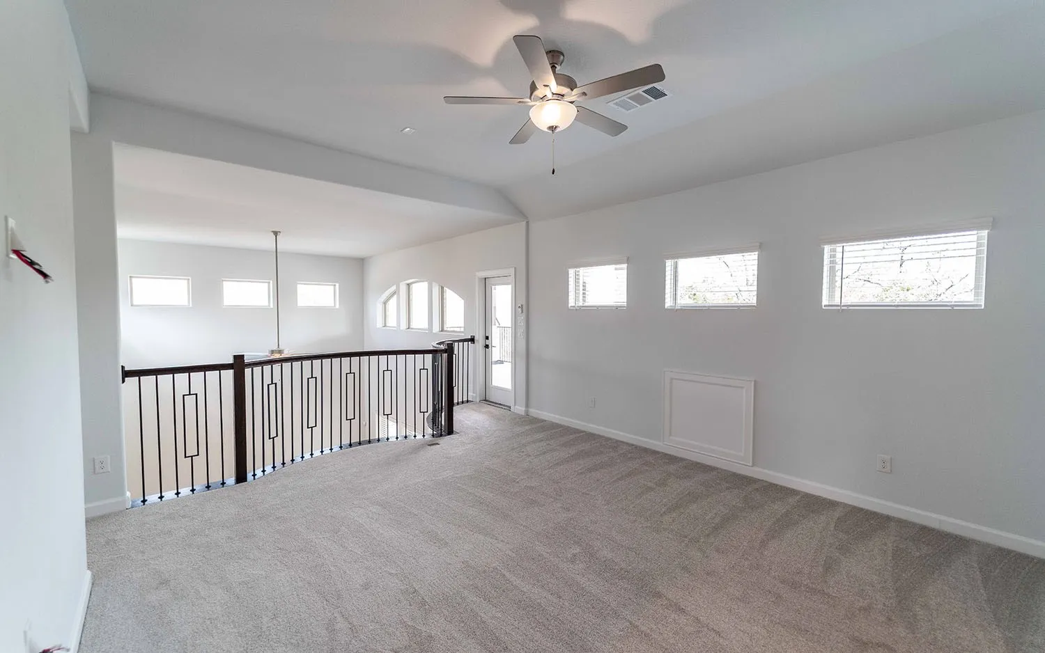 Spacious loft area with vaulted ceilings, recessed lighting, and a ceiling fan