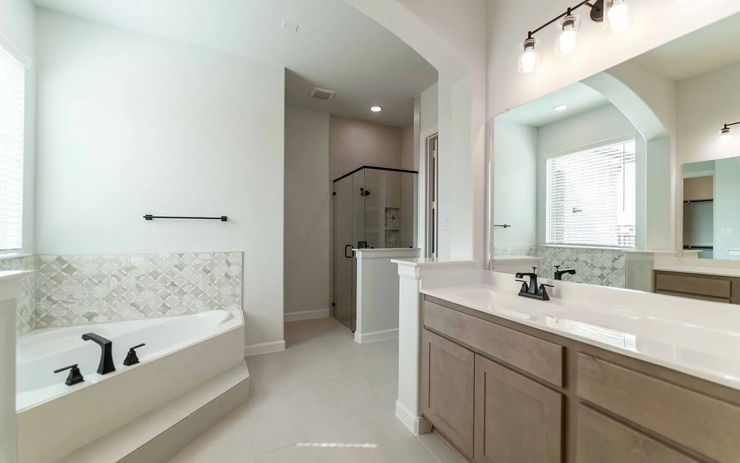 Dual vanity with white countertops, undermount sinks, and matte black fixtures
