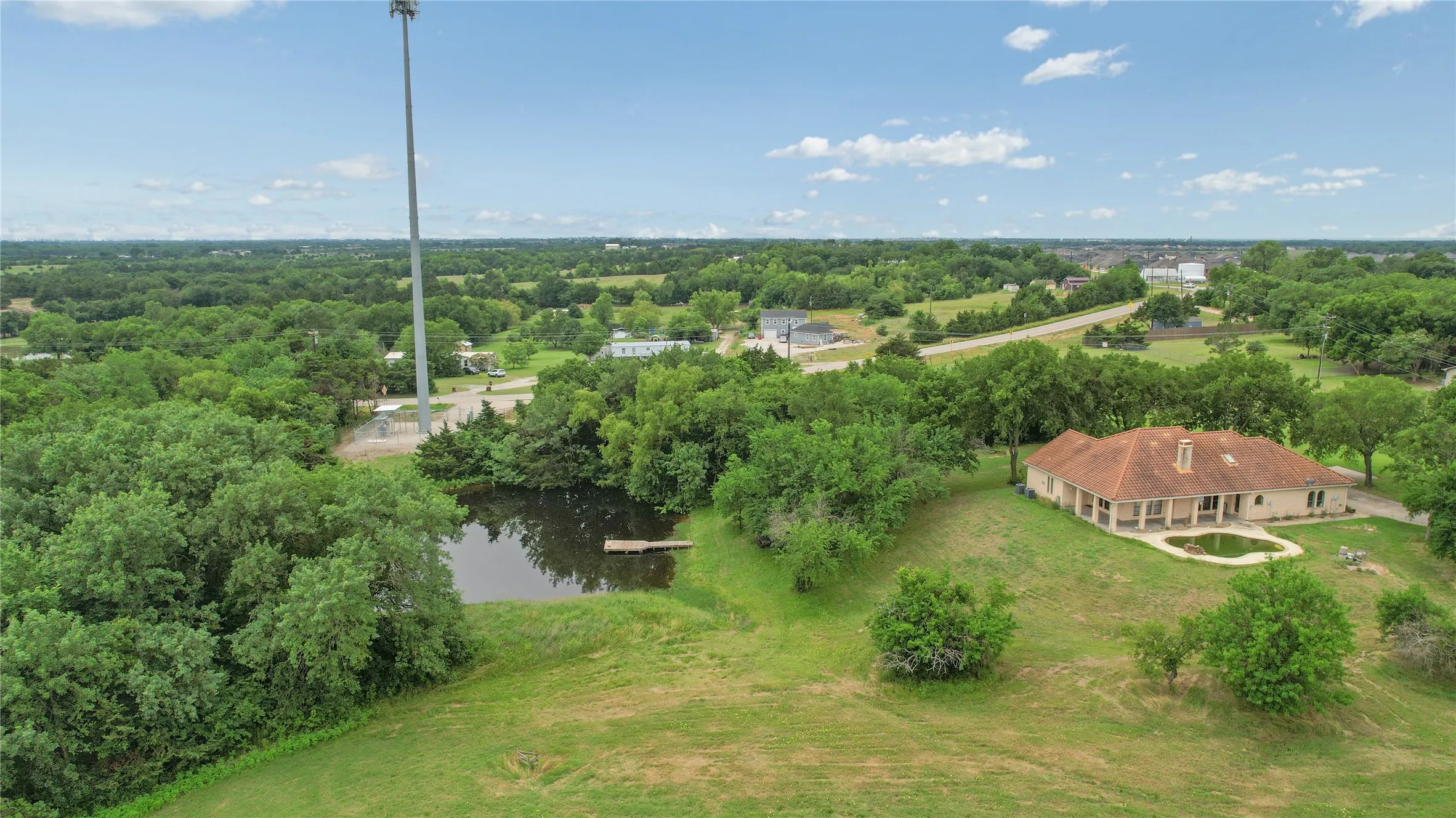 Aerial view of property and surrounding area with a nearby body of water