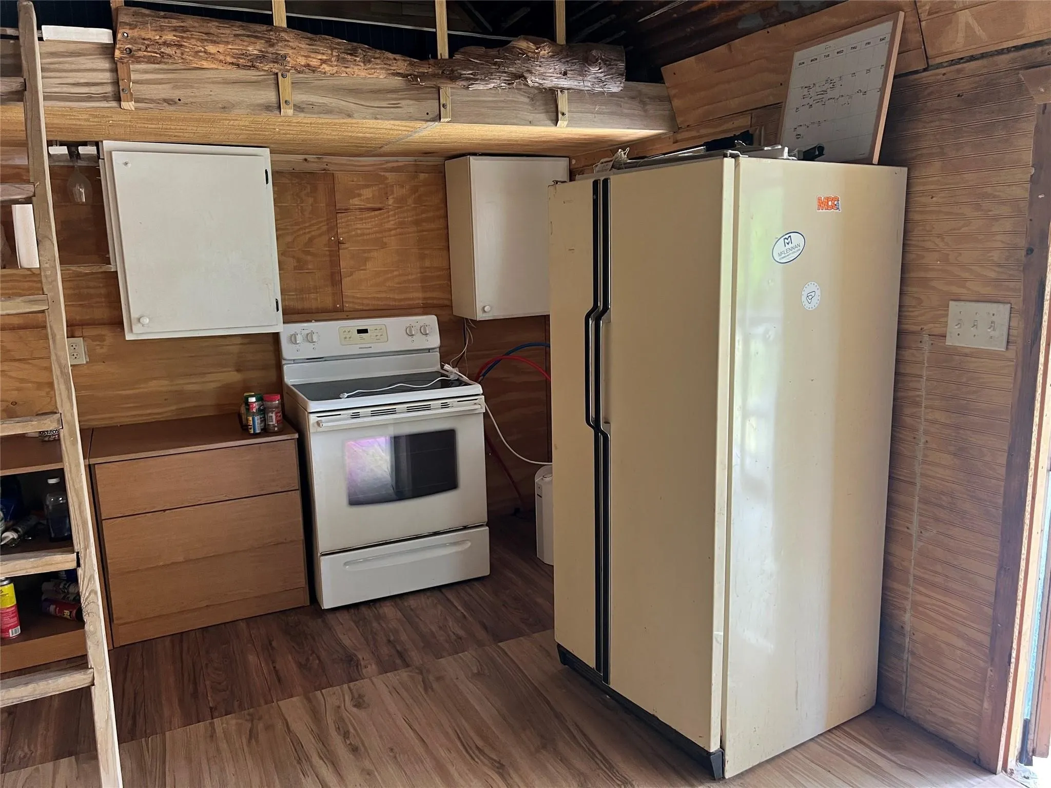 Kitchen featuring white appliances and wood finished floors
