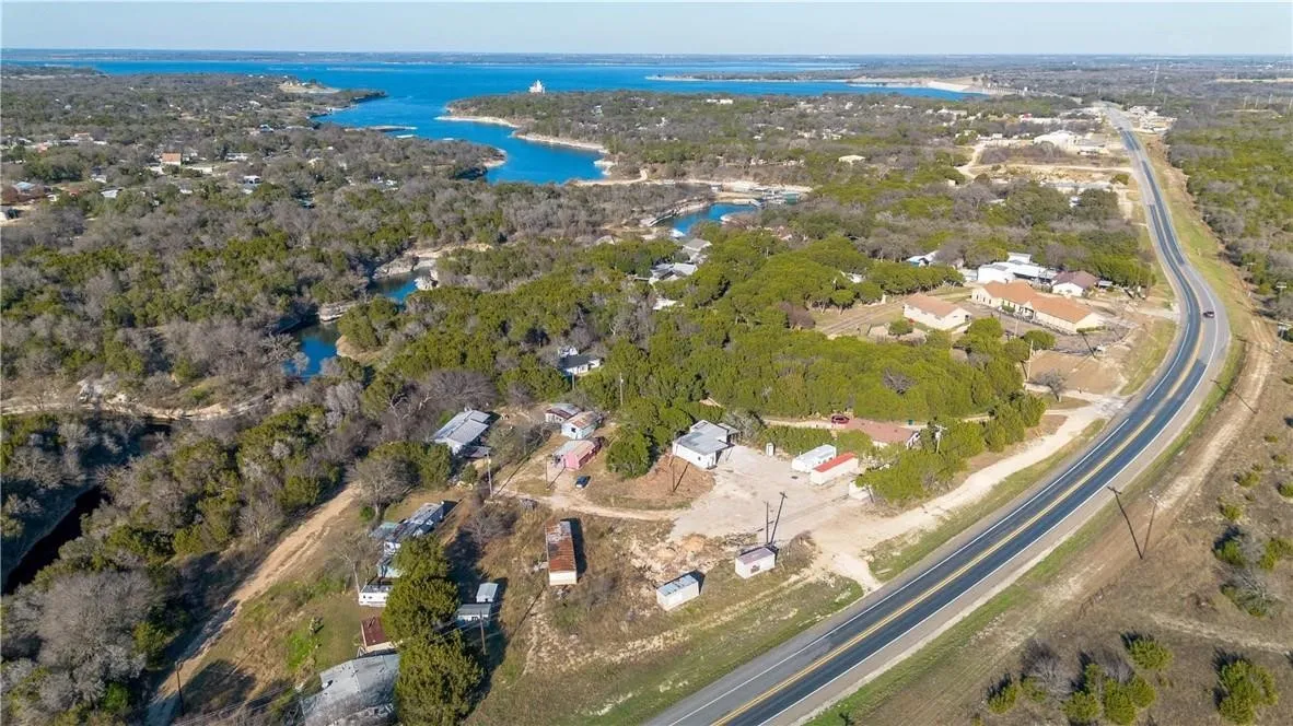 Aerial view of property and surrounding area with a nearby body of water