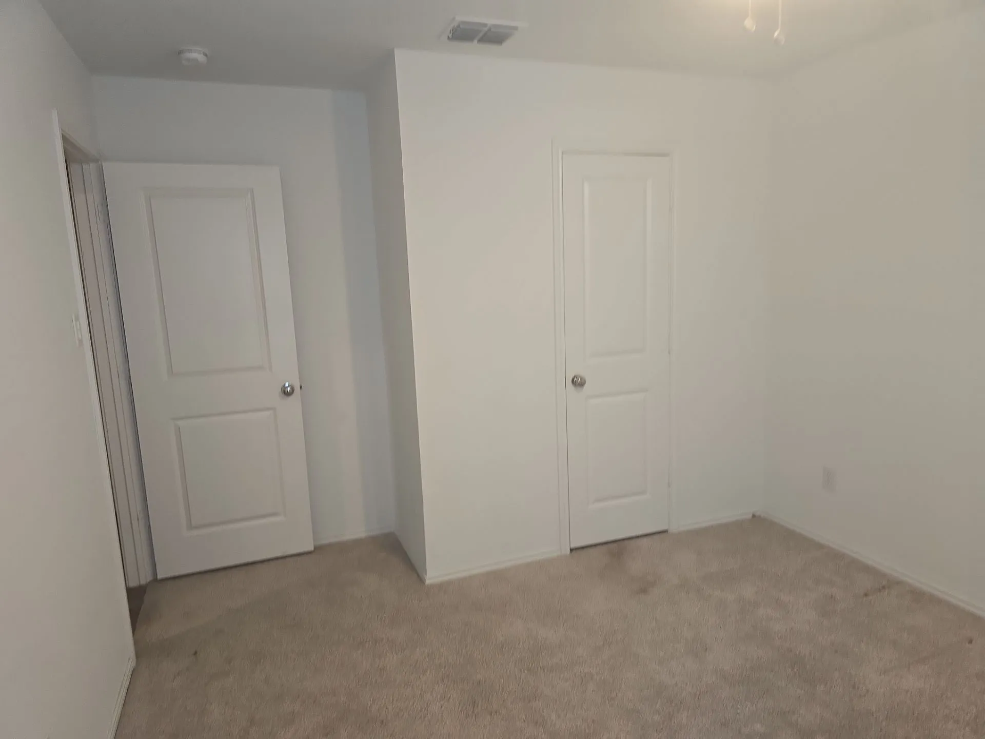 Unfurnished bedroom with light carpet