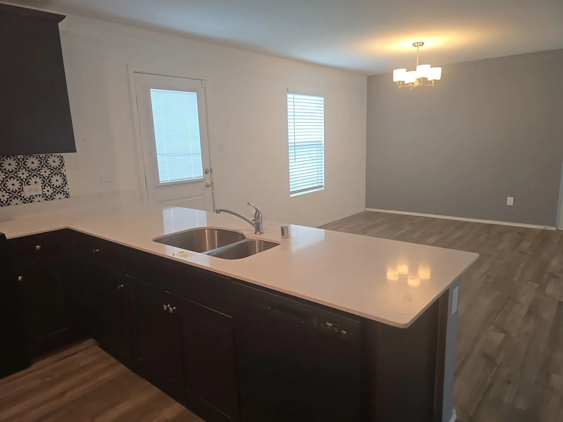 Kitchen with a chandelier, dark cabinetry, dark wood finished floors, and a peninsula