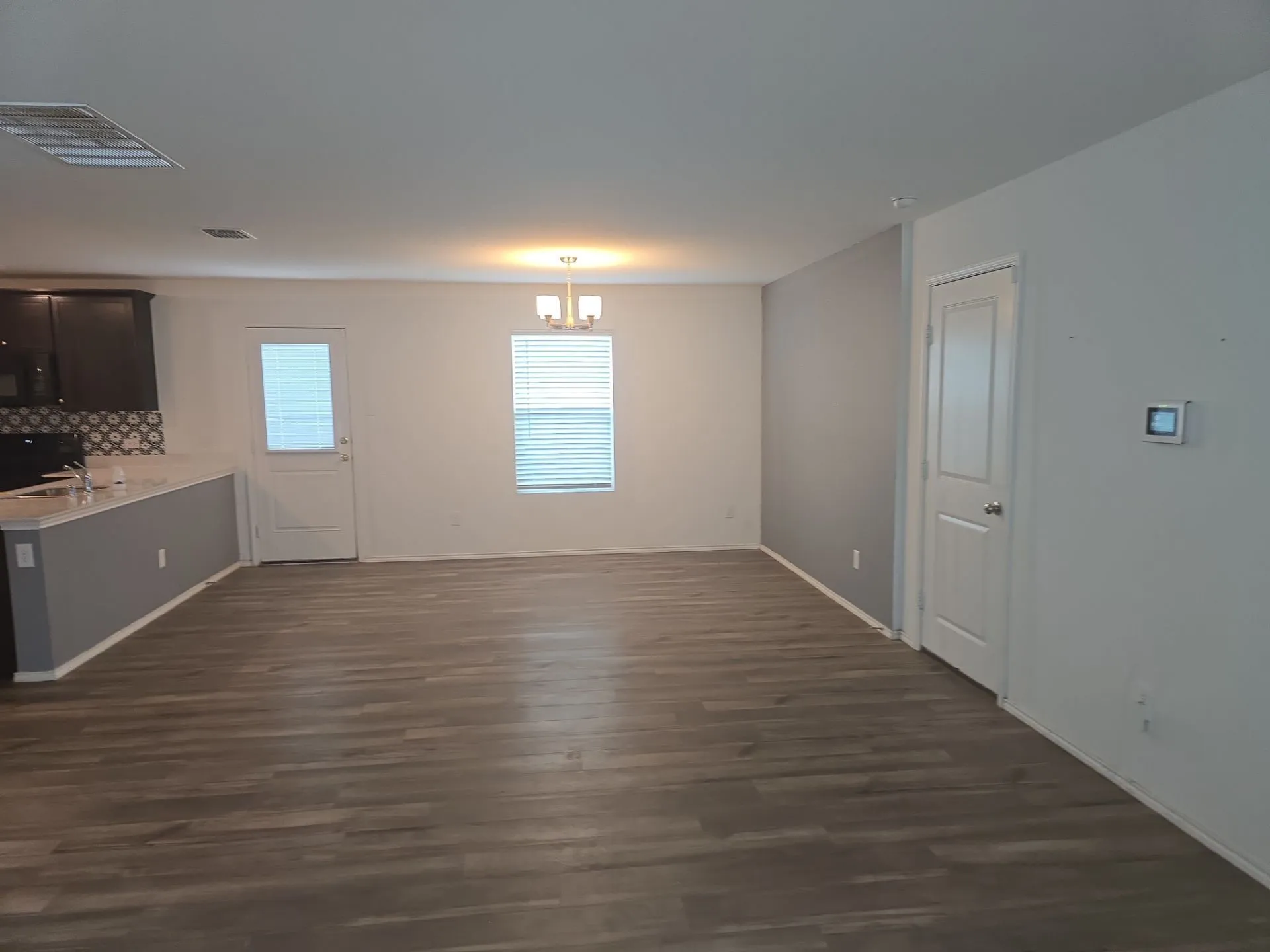 Unfurnished dining area with a chandelier and dark wood-style flooring