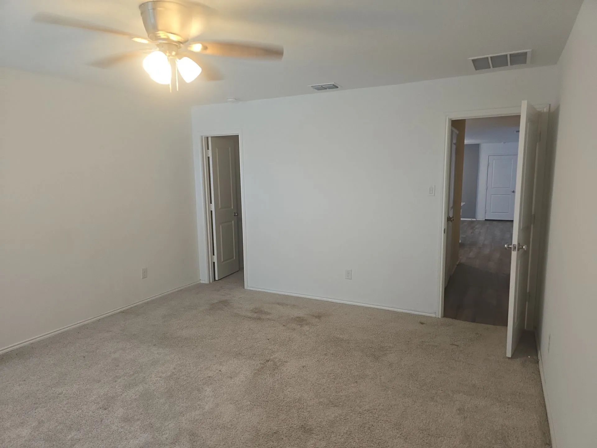 Carpeted spare room featuring a ceiling fan