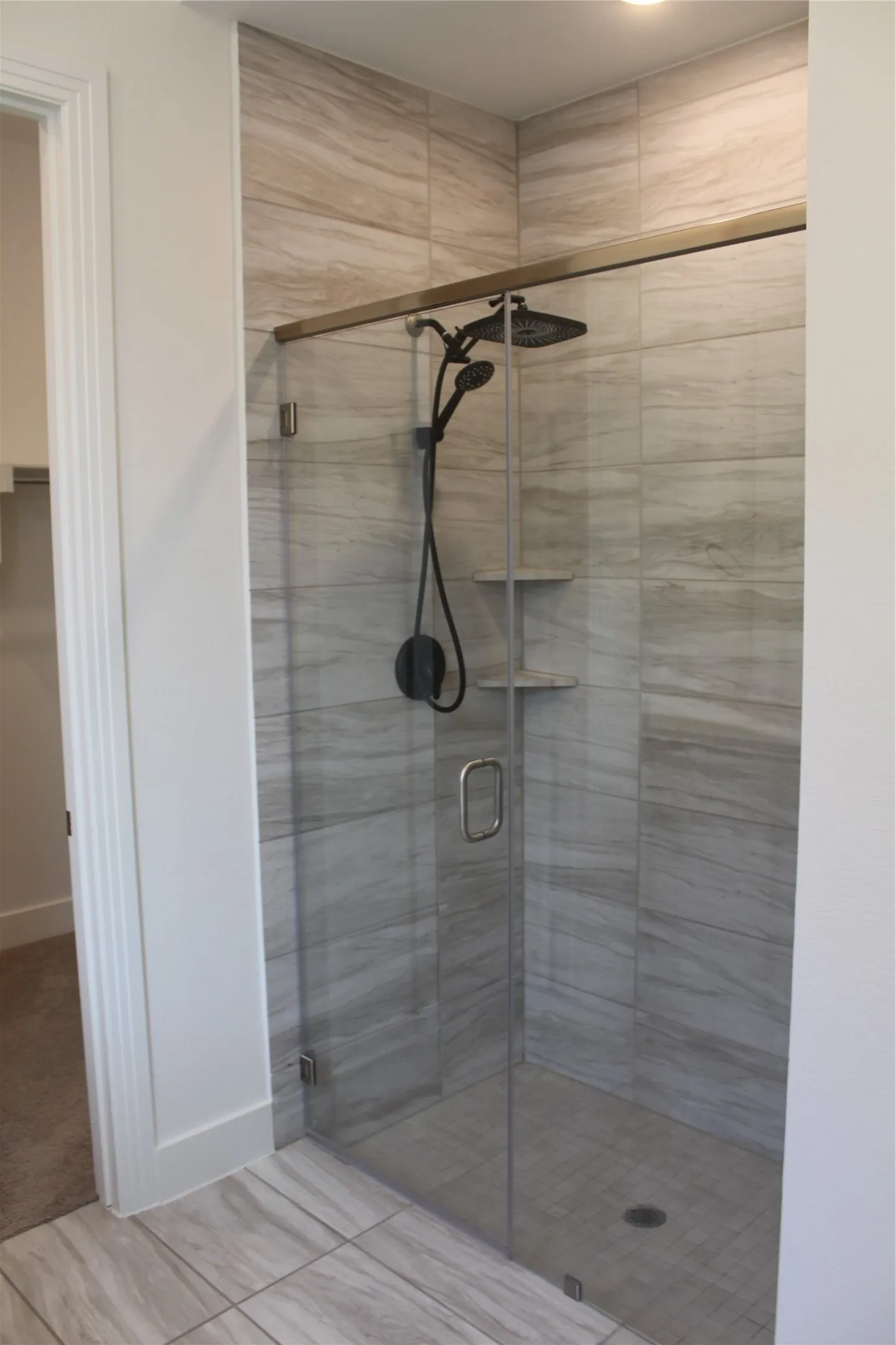 Full bathroom featuring a shower stall and baseboards