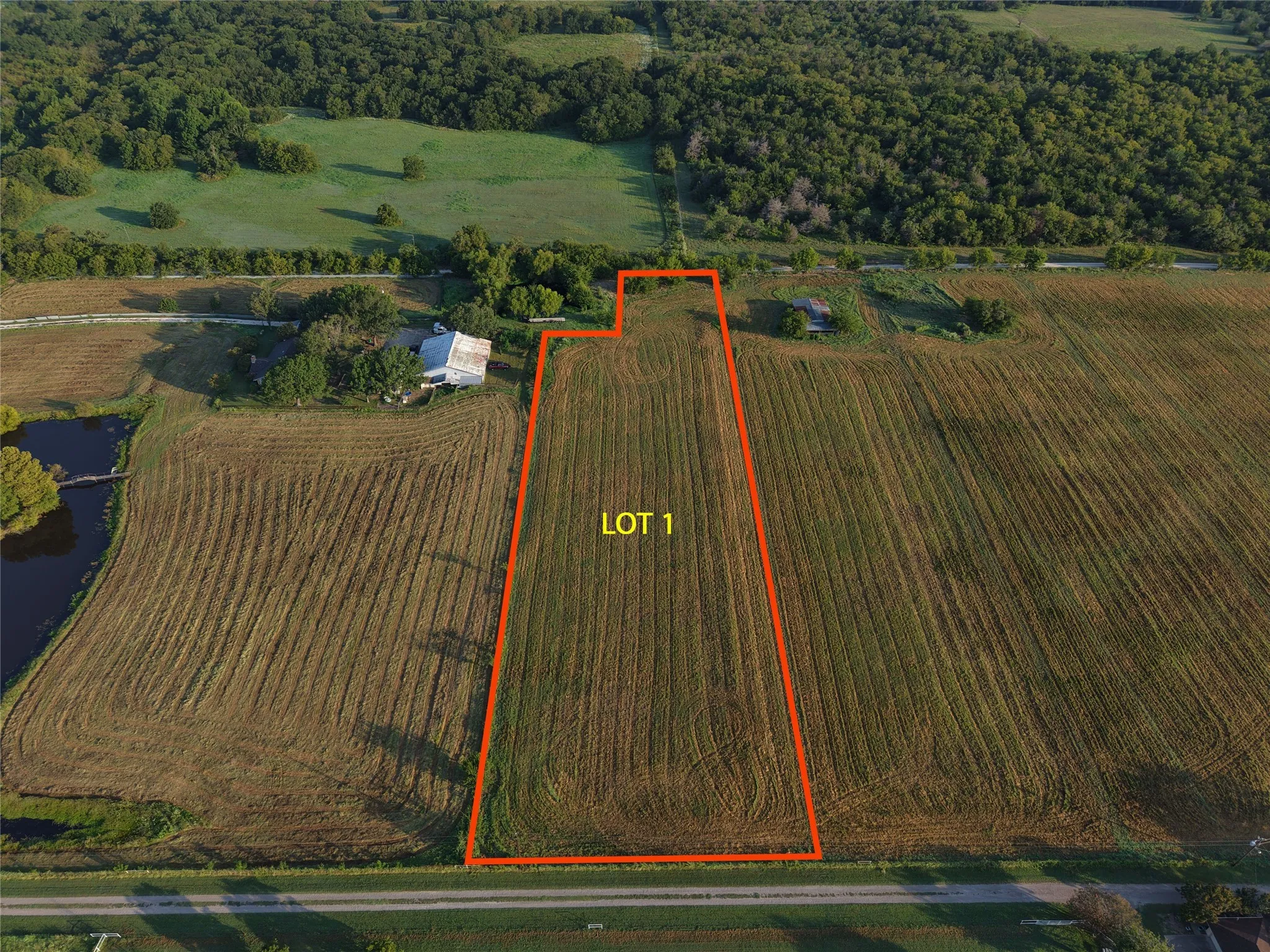 Aerial view of property and surrounding area featuring property parcel outlined and a nearby body of water